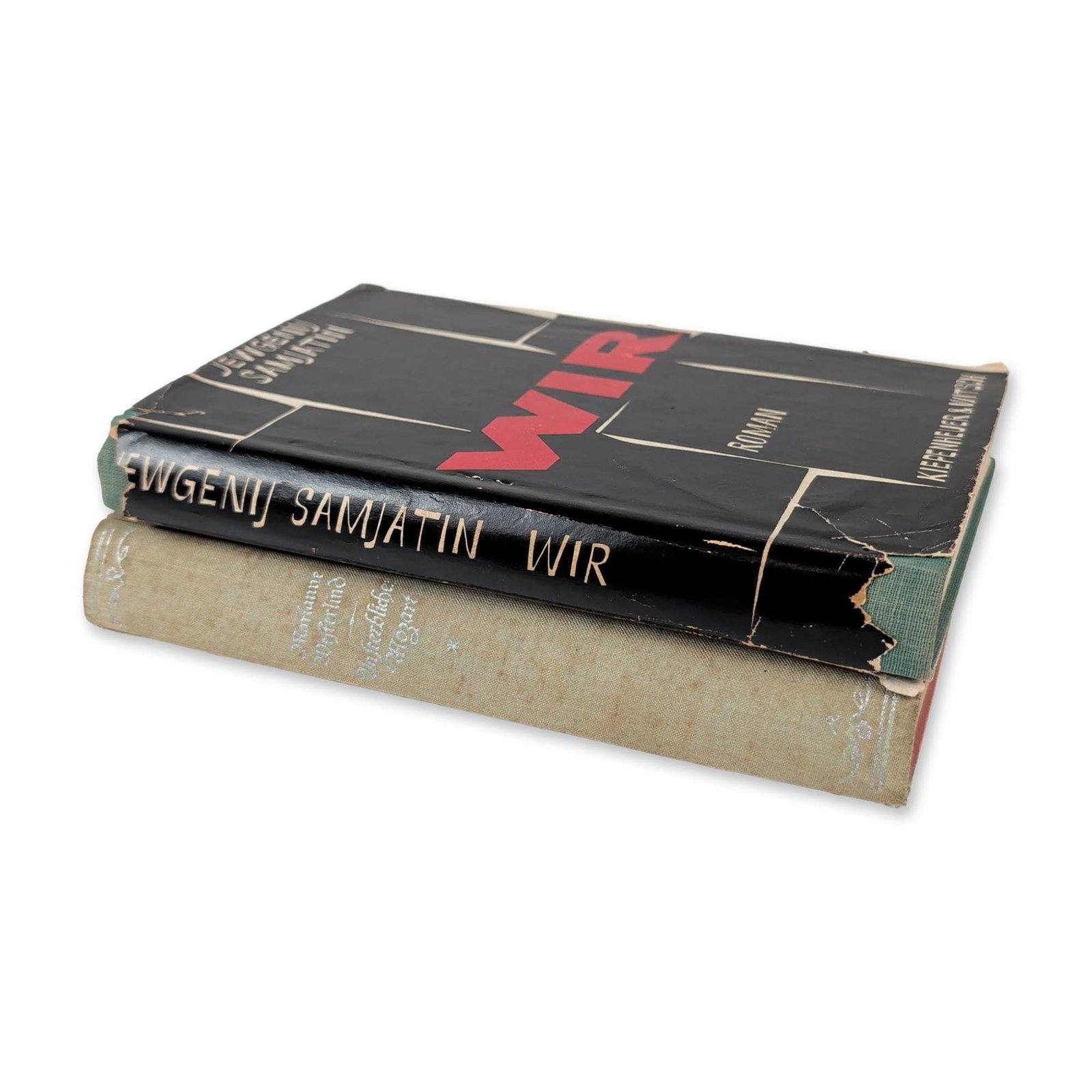 2 German Language Hardcover Books, Wir and Unsterblicher Mozart: The first is a first edition of Jewgenij Samjatin's novel "Wir", published by Kiepenheuer & Witsch, Cologne, 1958. The volume features green cloth binding and retains its original black and red dust