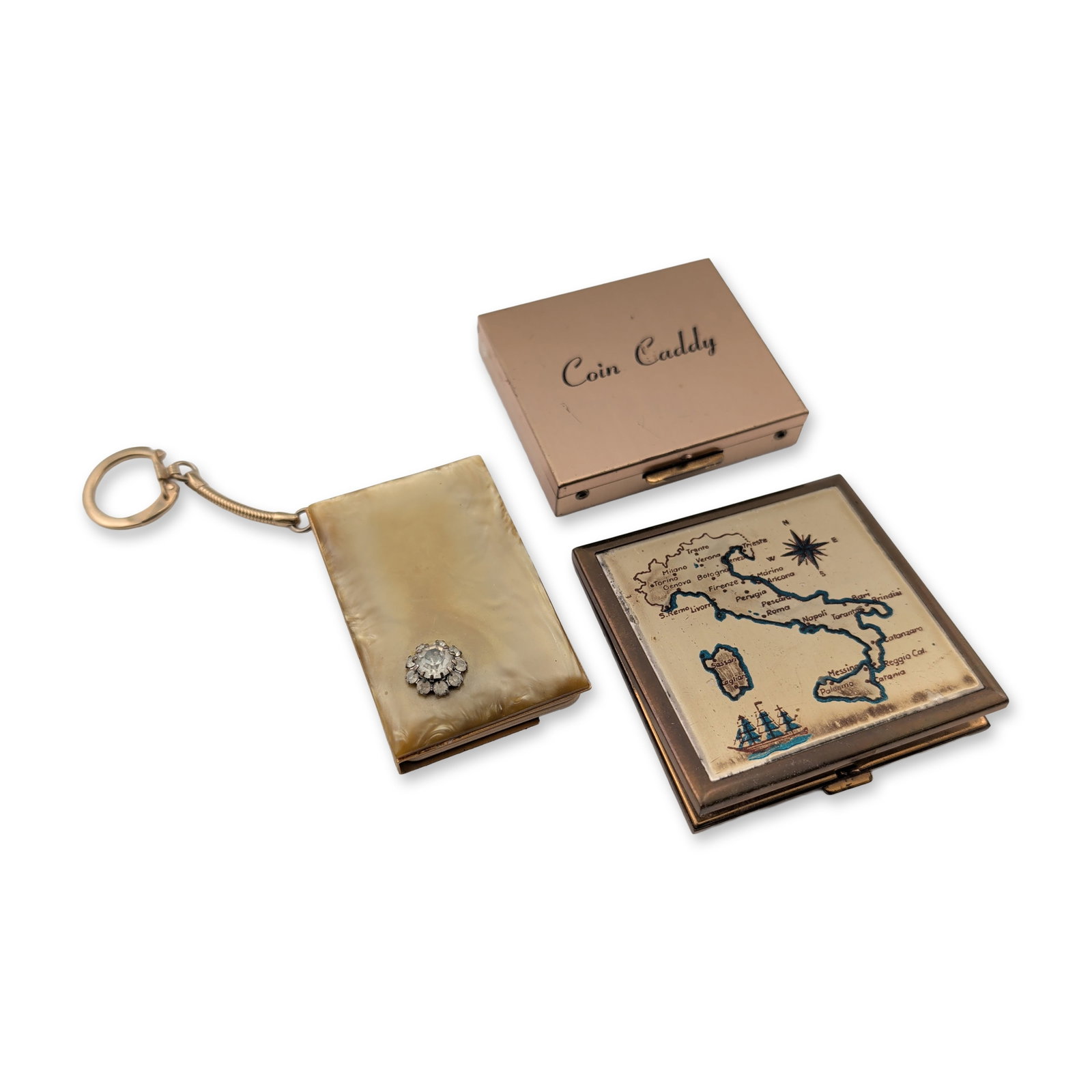 3pc Mid-Century Gold-Tone Coin Dispenser, Powder Compact & Address Book Keychain: Collection of three mid-century personal accessories including a coin dispenser, a souvenir powder compact, and an address book keychain. The Coin Caddy pocket purse is constructed of gold-tone metal 
