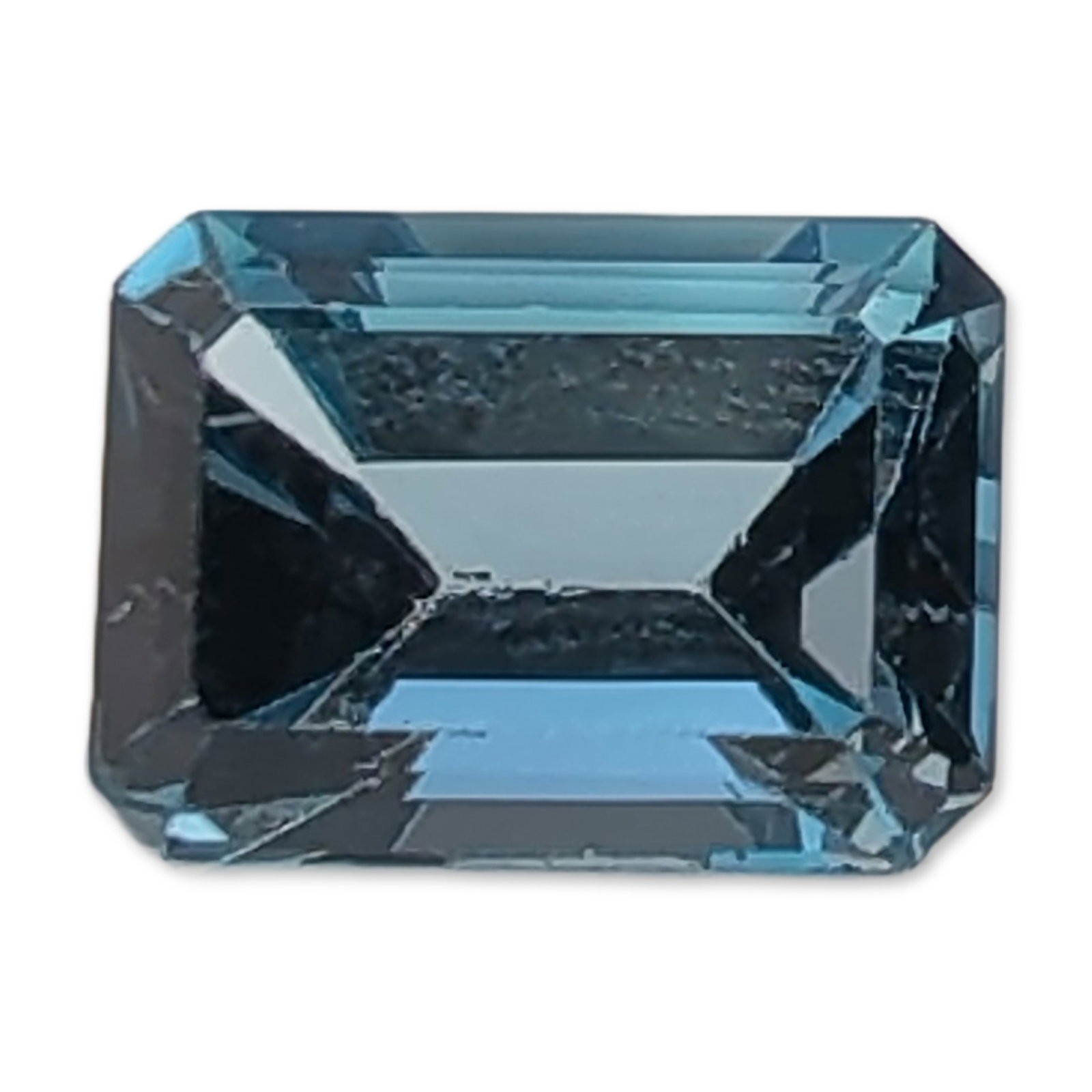 Emerald Cut Loose Gemstone London Blue Topaz: Loose faceted Topaz gemstone in a rectangular emerald cut, featuring a deep saturated blue color with slight teal undertones, characteristic of London Blue Topaz. The stone displays clipped corners