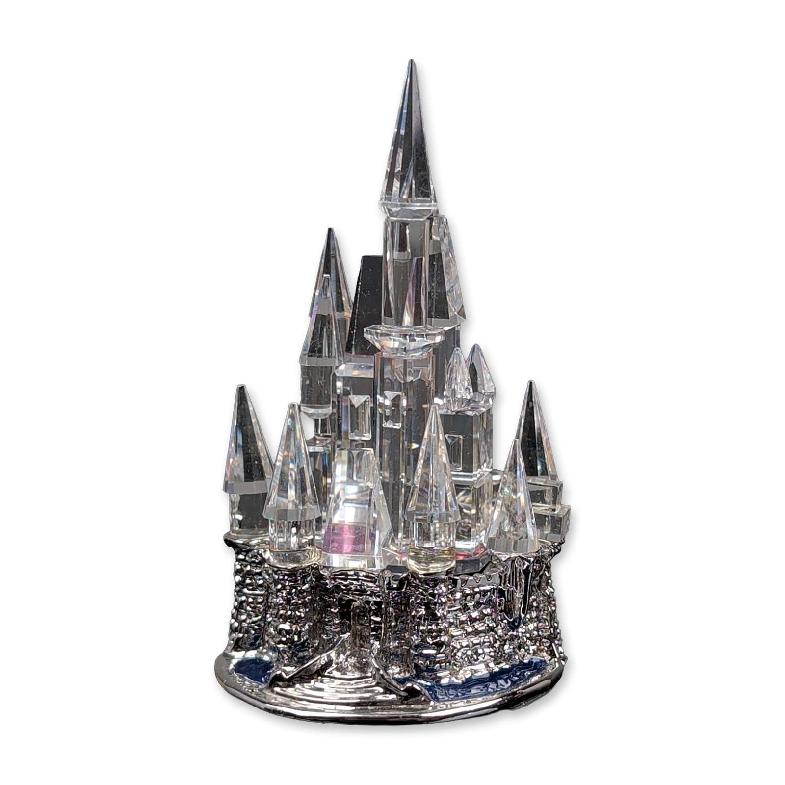 Arribas Bros Disney Crystal Magic Kingdom Castle Figurine: Arribas Bros. Miniature Disney Magic Kingdom castle figurine in faceted lead crystal and silver-tone metal, depicted with multi-faceted spires and a pave-textured metal base. Base rim is stamped with 