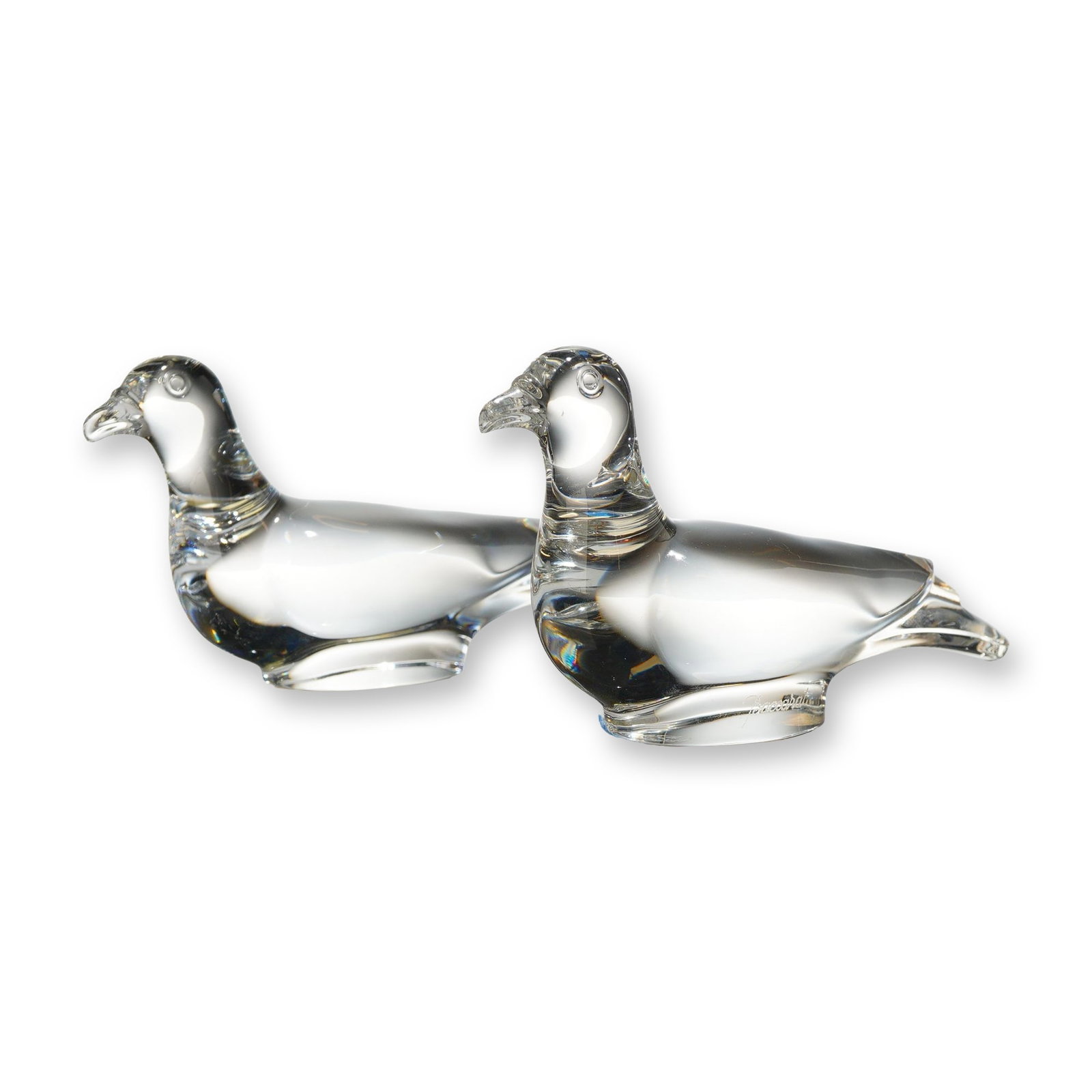 Pair of Baccarat Clear Crystal Resting Dove Figurines: This lot features a pair of solid clear lead crystal figurines by Baccarat, France. Each piece depicts a resting bird, typically identified as a dove or pigeon, designed in a stylized modern form with