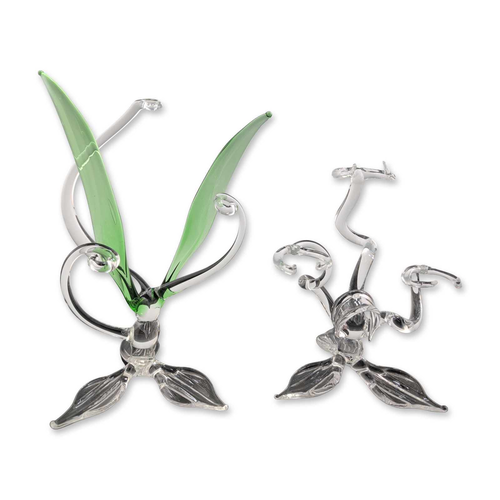 Two Hand-Blown Glass Stylized Plant Sculptures: Pair of hand-blown glass sculptures in stylized botanical-hybrid forms. One example is crafted in colorless clear glass, while the second incorporates pale, green-tinted wing elements. Each piece feat