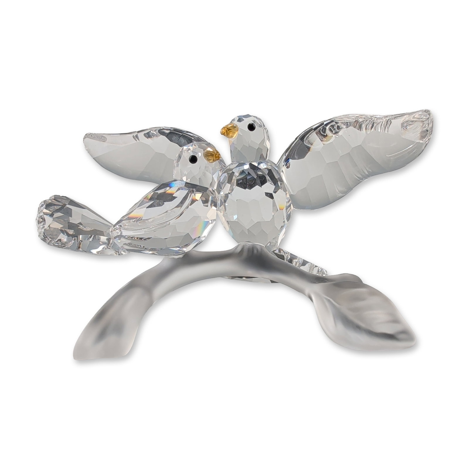 Swarovski Crystal Turtledoves Figurine: Swarovski. Turtledoves figurine in clear faceted and frosted crystal, featuring two birds perched on a stylized branch. The birds are constructed from faceted lead crystal with black bead eyes and yel