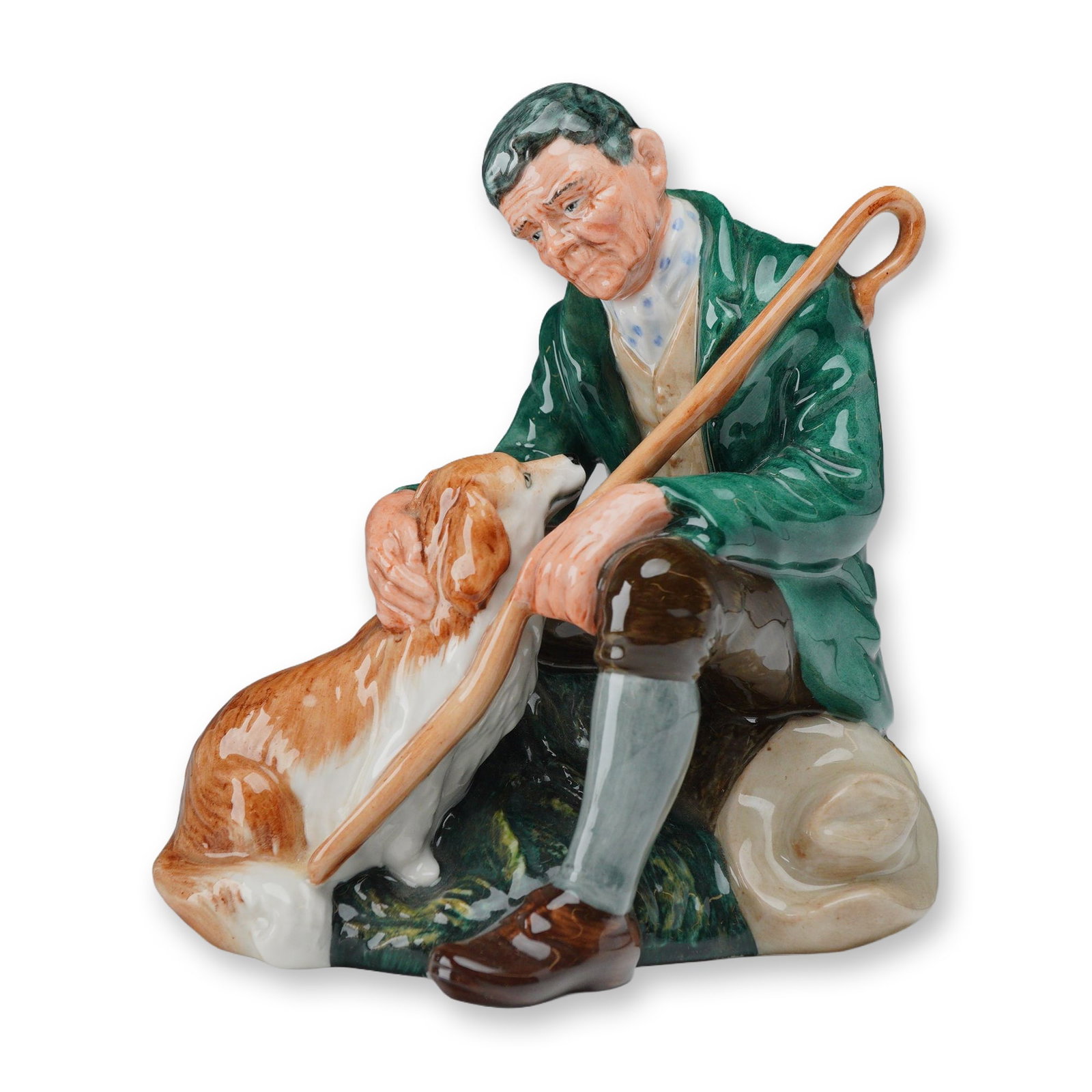 Royal Doulton Glazed Porcelain Figurine The Master HN 2325: A Royal Doulton glazed porcelain figurine titled The Master, model number HN 2325. This character study depicts an elderly countryman or shepherd seated upon a fallen log. The man is dressed in tradit