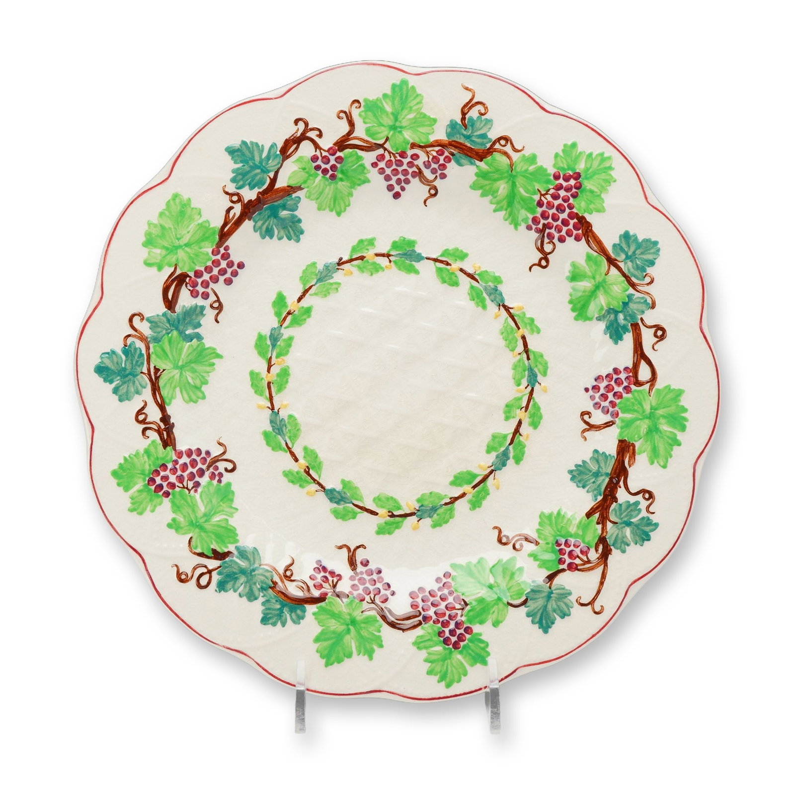 Wedgwood Etruria Hand-Painted Earthenware Grapevine Plate: The piece features a scalloped rim and a molded wicker texture in the center well. It is decorated with hand-painted motifs, including a continuous grapevine border on the rim featuring clusters of re