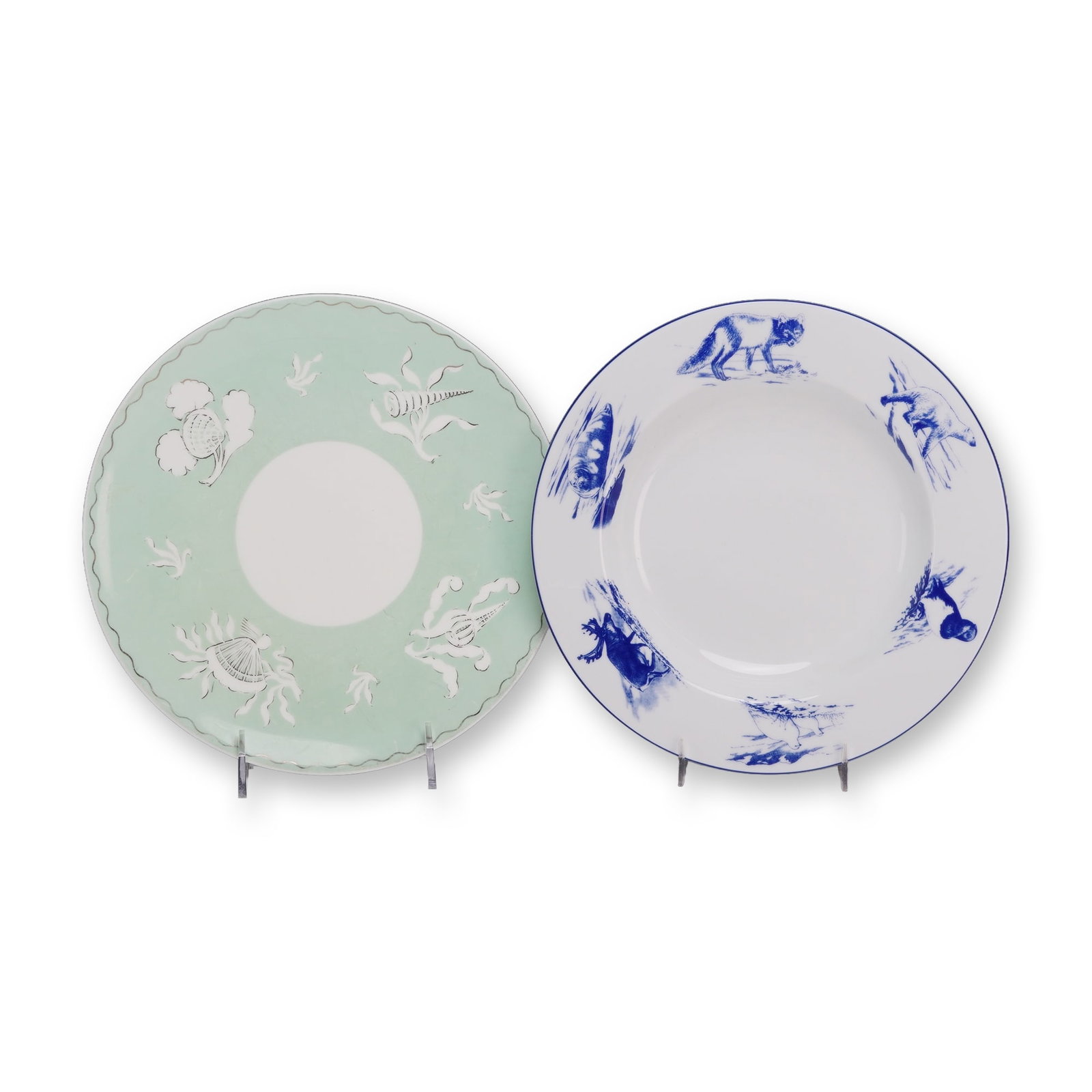 Two Ceramic Plates by Wedgwood and Porsgrund: This lot features two ceramic plates from European manufacturers. The first is a Wedgwood scalloped luncheon plate featuring a pale celadon green border surrounding a white central well. The border is