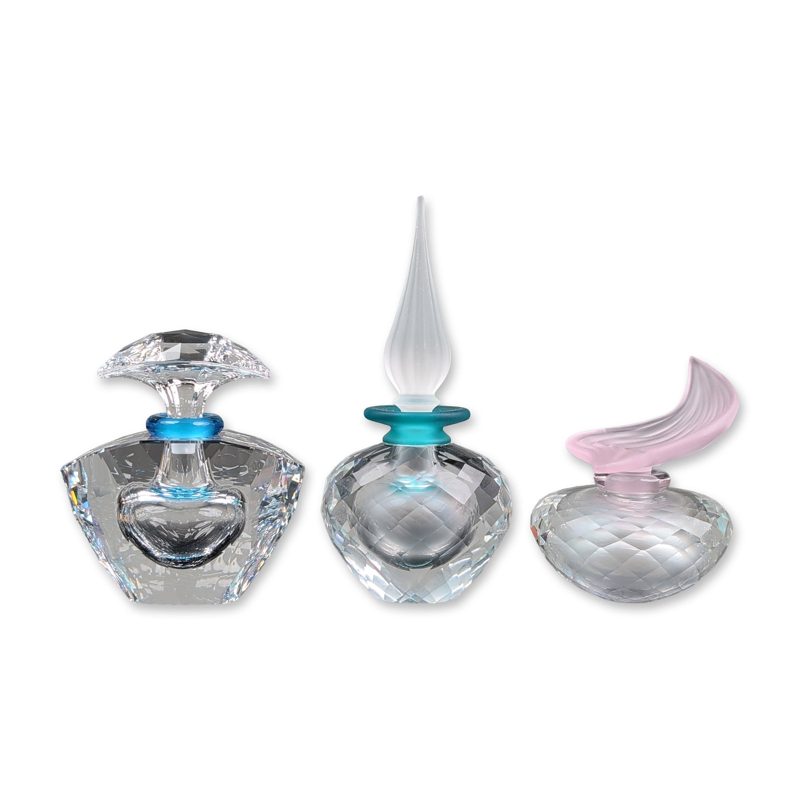 3pc Swarovski Silver Crystal Perfume Bottles: Three Swarovski decorative faceted crystal perfume bottles, featuring clear faceted glass bodies with colored glass neck rings and sculptural stoppers. The group includes one bottle with a blue glass 