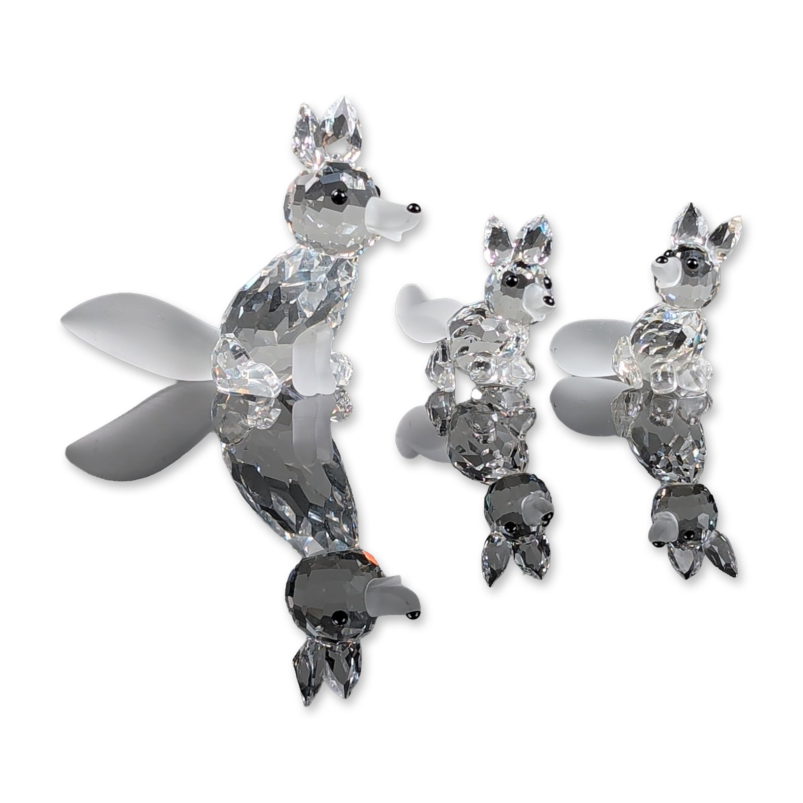 3pc Swarovski Silver Crystal Fox Family Figurines: Swarovski Silver Crystal trio of fox figurines, including one large seated fox and two smaller kits in varied poses. The figures are constructed from faceted clear lead crystal with contrasting froste