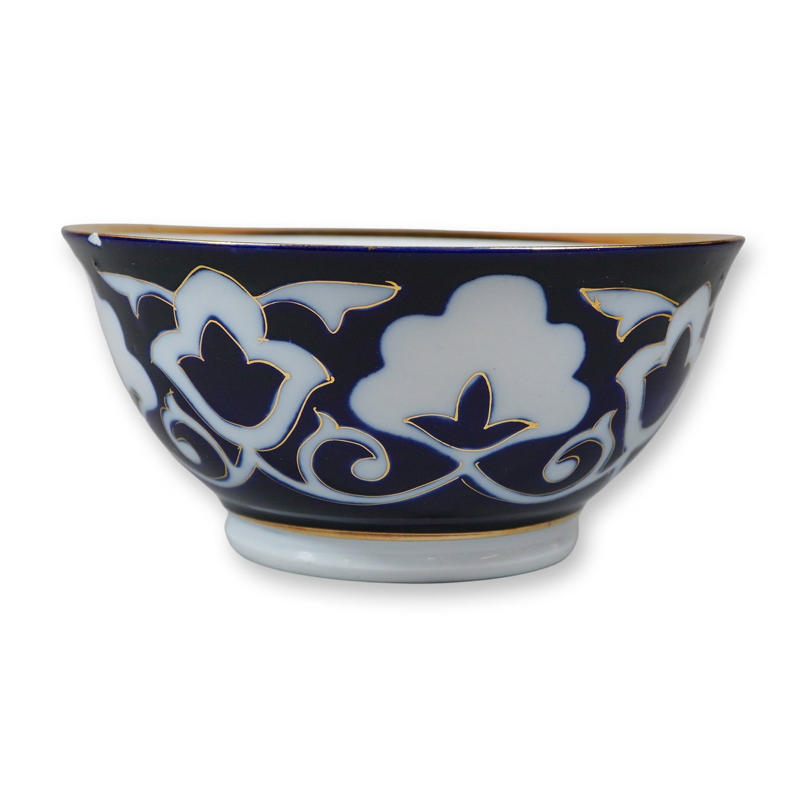 Tashkent Uzbek Porcelain Blue and Gilt Pahta-Motif Bowl: The exterior of the bowl is decorated with a stylized white cotton motif, known as the Pahta design, against a deep cobalt-blue ground and enhanced with hand-applied gilt scrollwork and a gilded rim. 