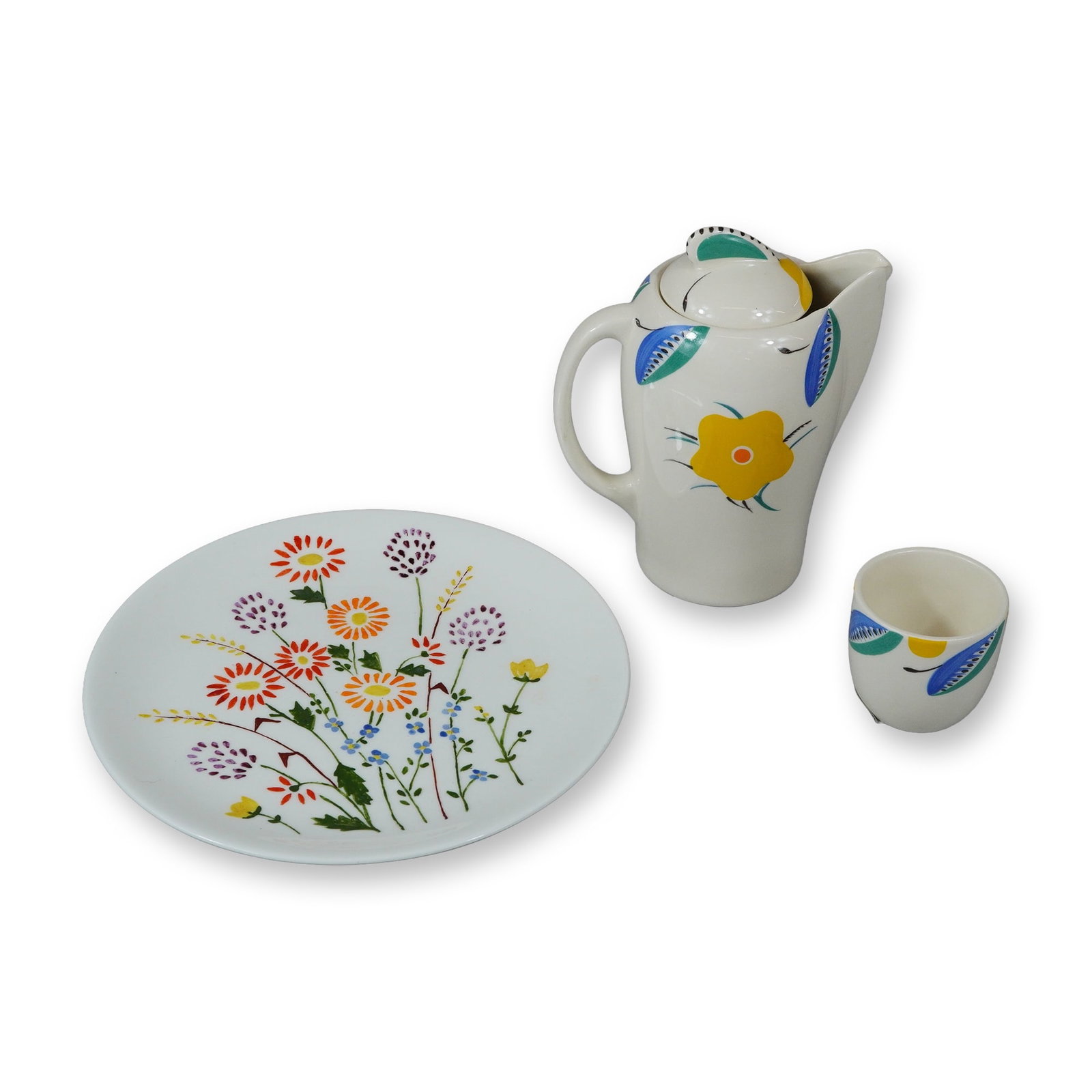 3pc Wedgwood Porcelain by Susie Copper Design Floral Plate, Cup, and Creamer: The group includes a covered pitcher with a sleek modernist form and petite finial, a handleless cup, and a circular plate. The plate is decorated with a colorful wildflower motif featuring red, orang