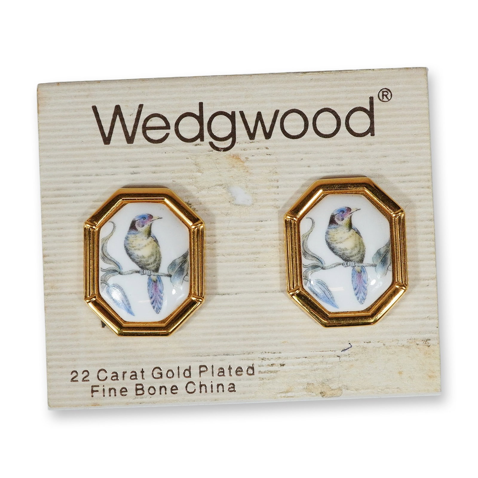 Pair of Wedgwood Gold Plated and Fine Bone China Bird Motif Clip-on Earrings: A matched pair of vintage Wedgwood clip-on earrings featuring octagonal frames. Each earring is constructed with a gold-plated base metal frame characterized by a ribbed border. The center of each ear