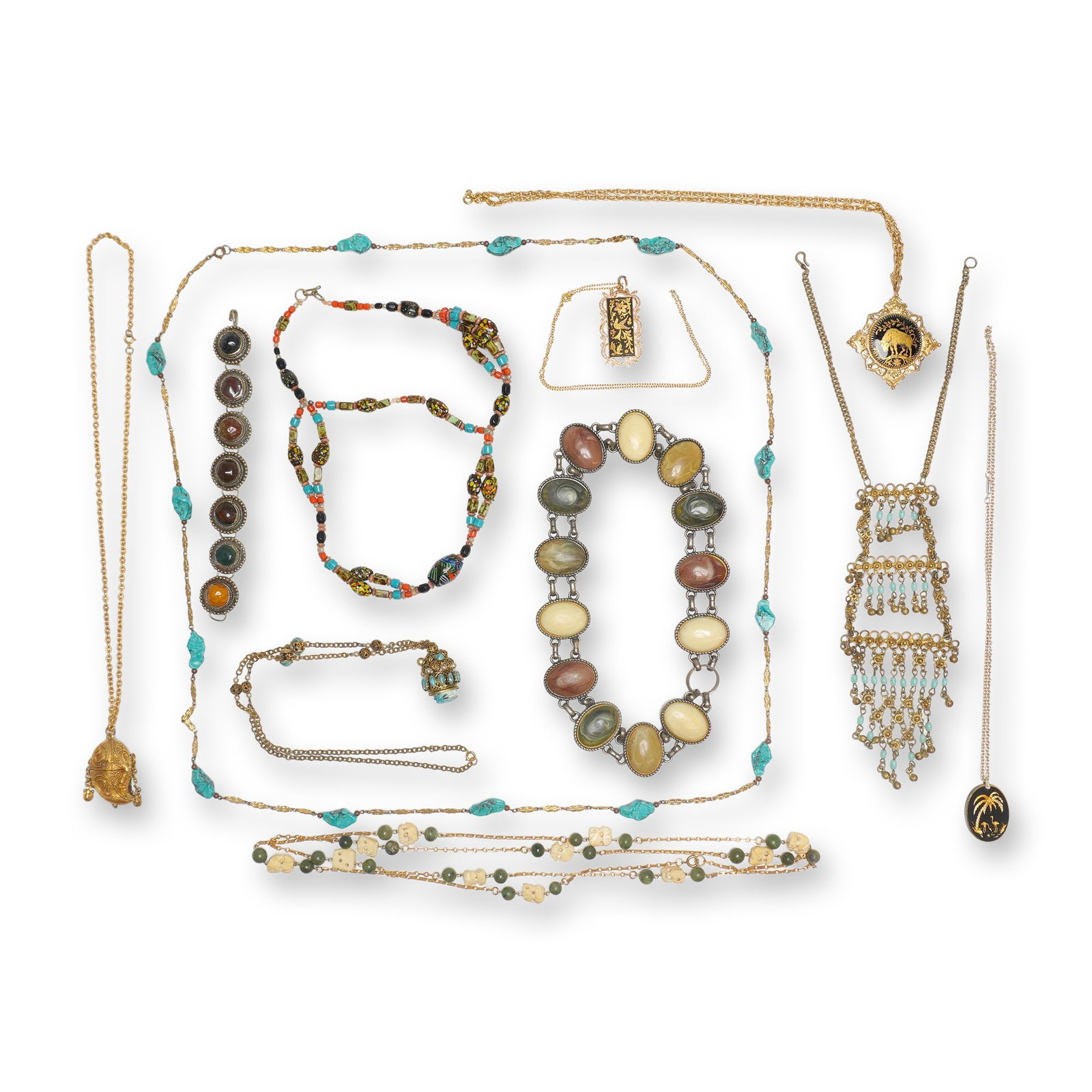 Gold and Silver-Tone Costume Jewelry Lot, Egyptian Revival and Tribal Styles: This 11-piece jewelry lot consists of ten necklaces and one bracelet featuring a variety of vintage and costume designs. The collection includes an Egyptian Revival Pharaoh head pendant with a carved 