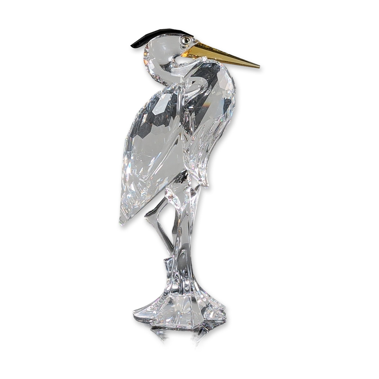 Swarovski 2005 Harmony Crystal Heron Figurine: Swarovski figurine part of the Feathered Friends series designed by Adi Stocker. Faceted clear lead crystal figurine of a heron featuring a yellow crystal beak and a black crystal head crest. The bird