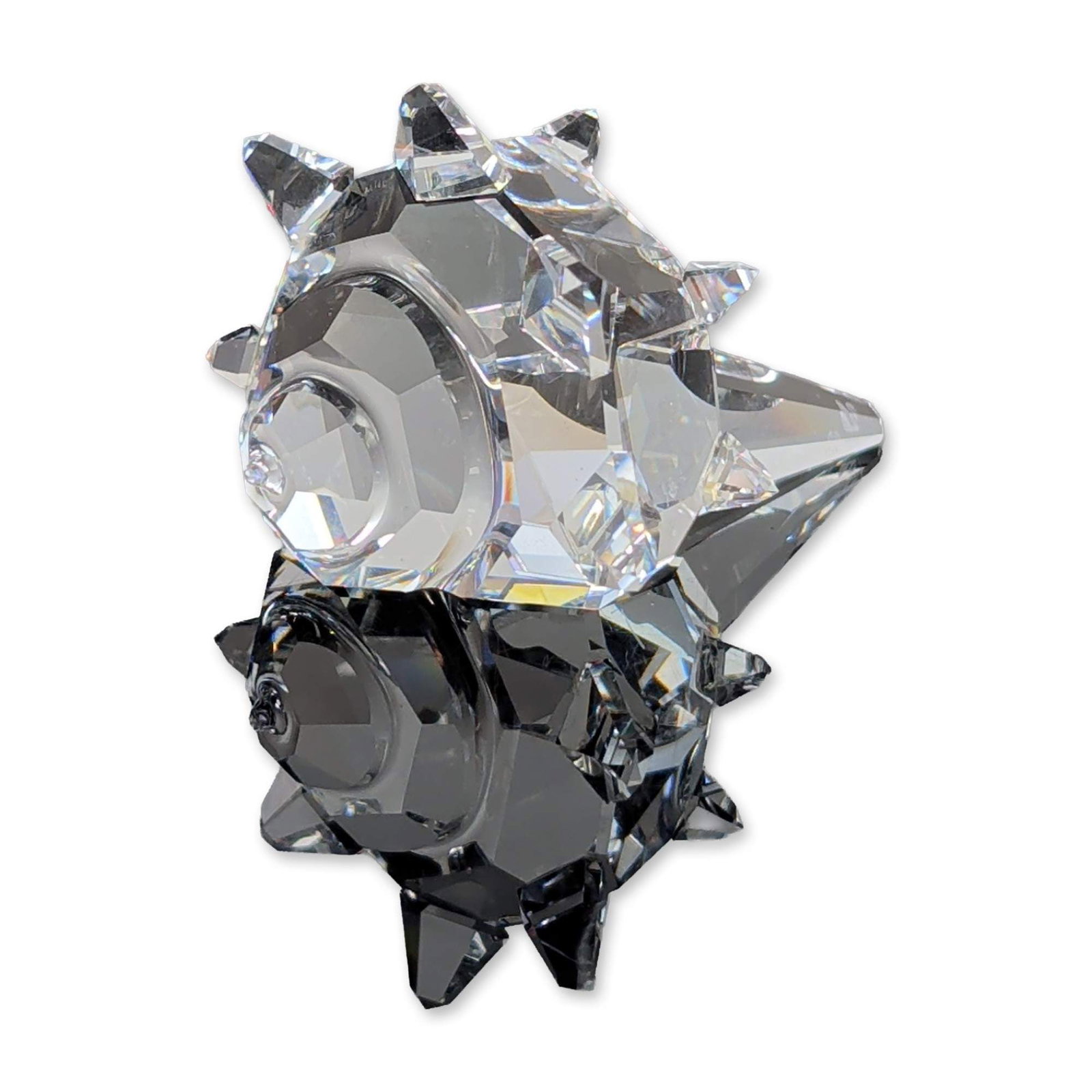 Swarovski Crystal South Sea Shell Figurine: South Sea Shell figurine in faceted clear lead crystal, part of the In the South Sea series. The piece features a stylized body and a spiny shell with multiple facets designed to capture and reflect l