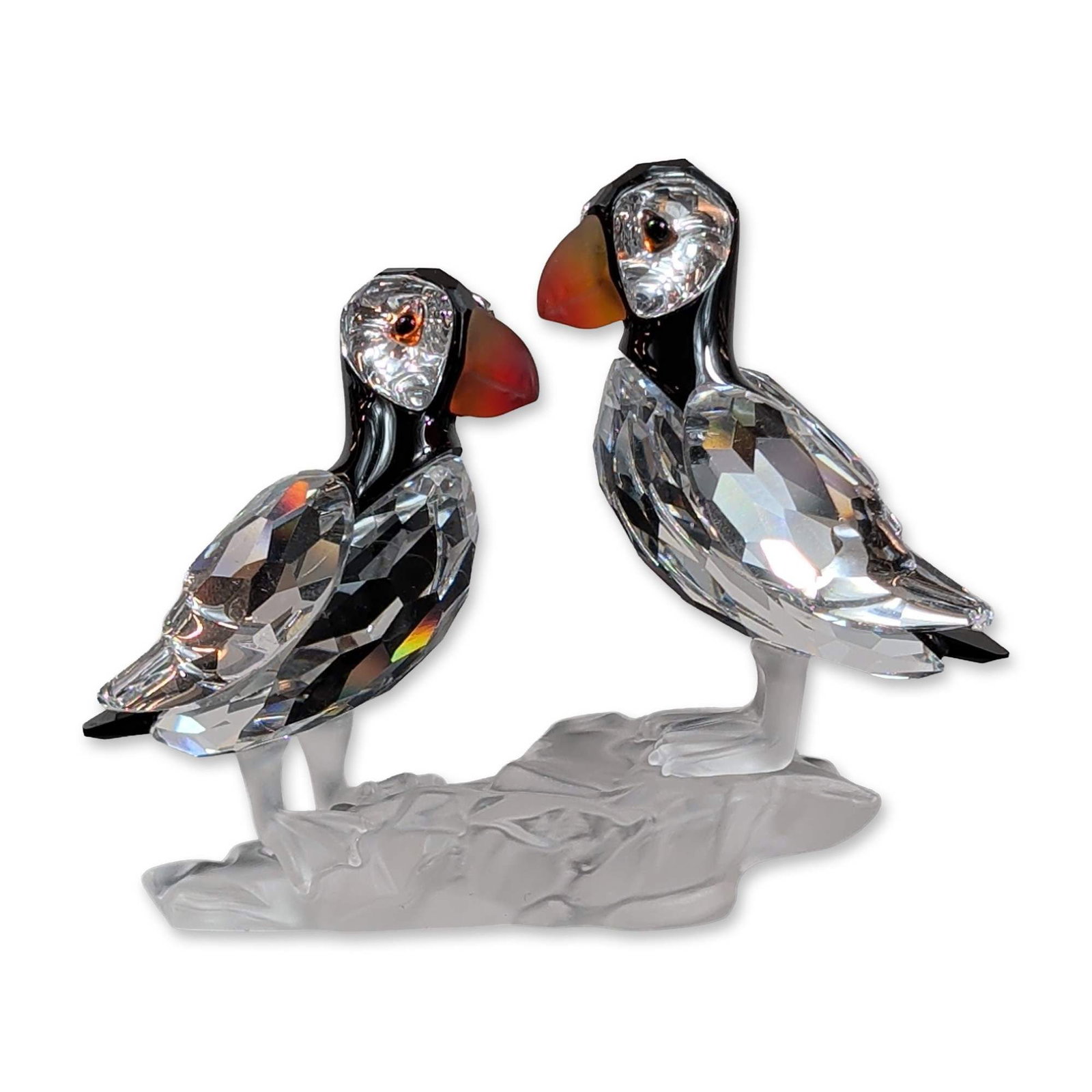 Swarovski Silver Crystal Puffins Figurine: Swarovski Silver Crystal. Pair of puffins figurine in faceted lead crystal, featuring clear faceted bodies with black crystal accents to the head and neck. Beaks are crafted in orange-red crystal. Bir