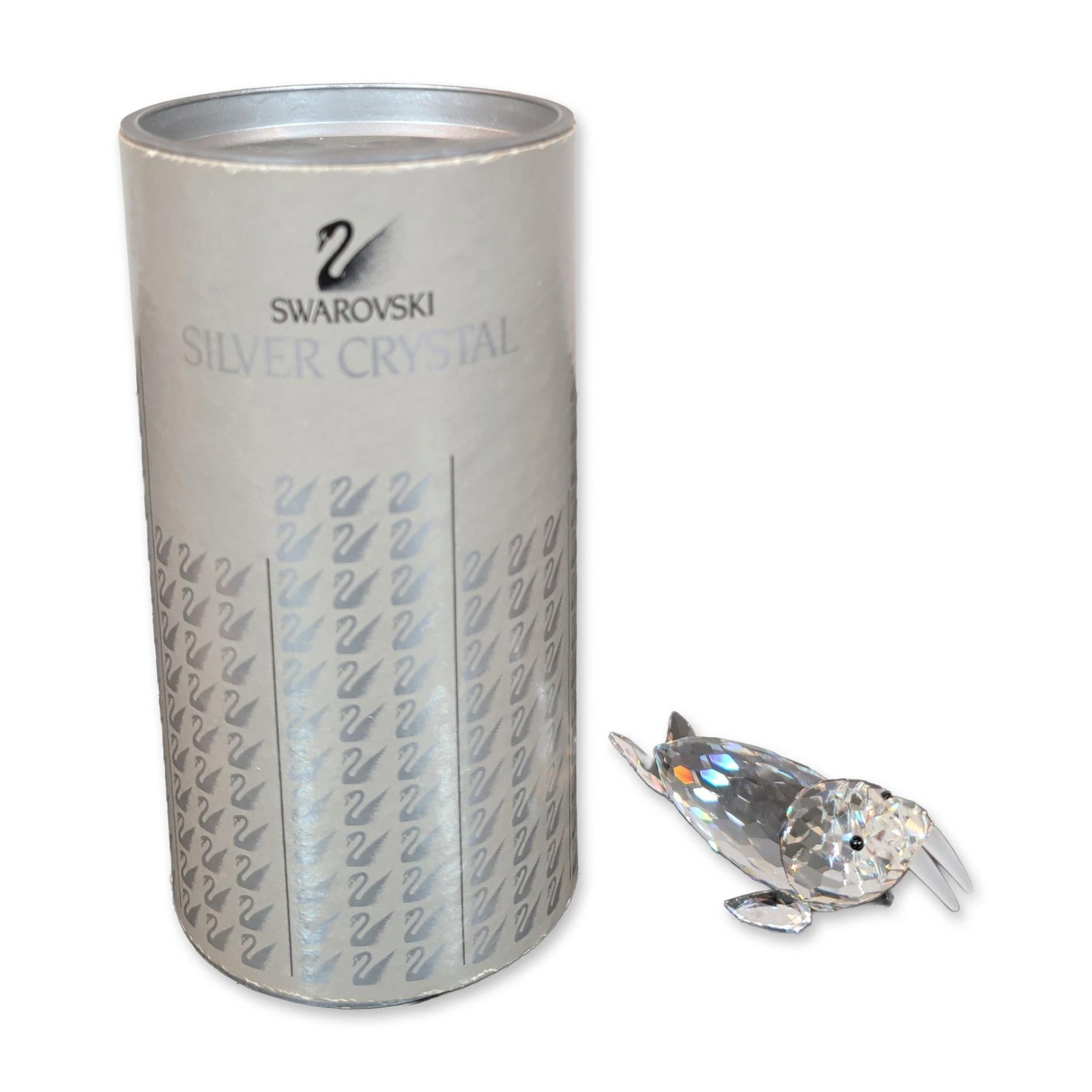 Swarovski Crystal Walrus Figurine: Swarovski Walrus figurine by Michael Stamey in faceted clear lead crystal, featuring two frosted crystal tusks and small black crystal chaton eyes. Etched signature and date to the underside. Includes