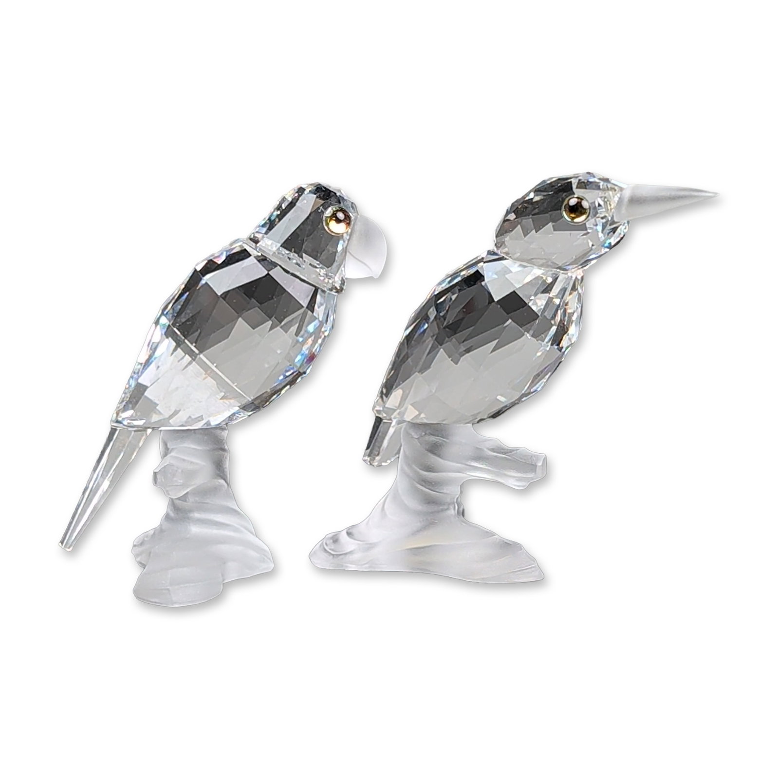 2pc Swarovski Silver Crystal Bird Figurines, Kingfisher and Parrot: Swarovski Silver Crystal featuring two birds perched on a branch in the Up in the Trees series. The birds are constructed from faceted clear lead crystal with frosted crystal crests, pointed beaks, an