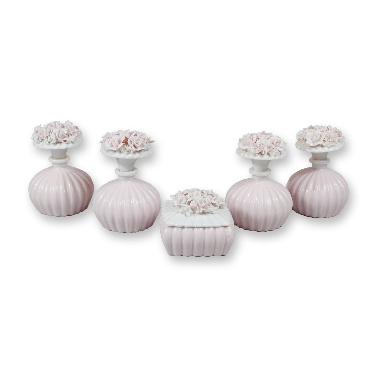 5pc Pink and White Floral Porcelain Vanity Set including Perfume Bottles and a Trinket Box: A five-piece pink and white flower porcelain vanity set consisting of four perfume bottles and one trinket box. The items are crafted from soft pink porcelain with a vertically ribbed or gadrooned bod