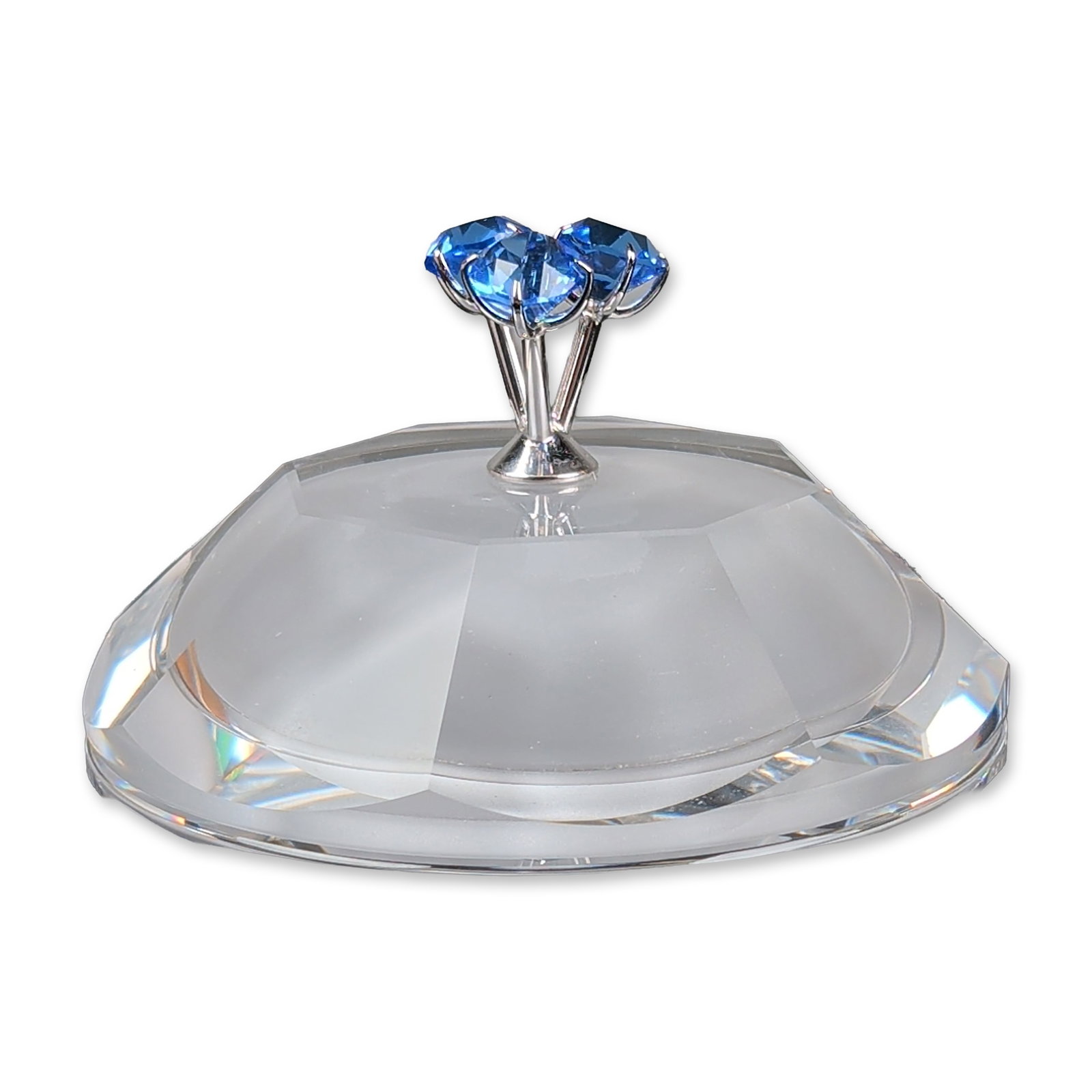 Swarovski Selection Astro Jewel Crystal Box: Constructed from faceted and frosted lead crystal, the circular vessel features a lid with a frosted center and clear faceted borders. The lid is topped with rhodium metal finial holding three blue fa