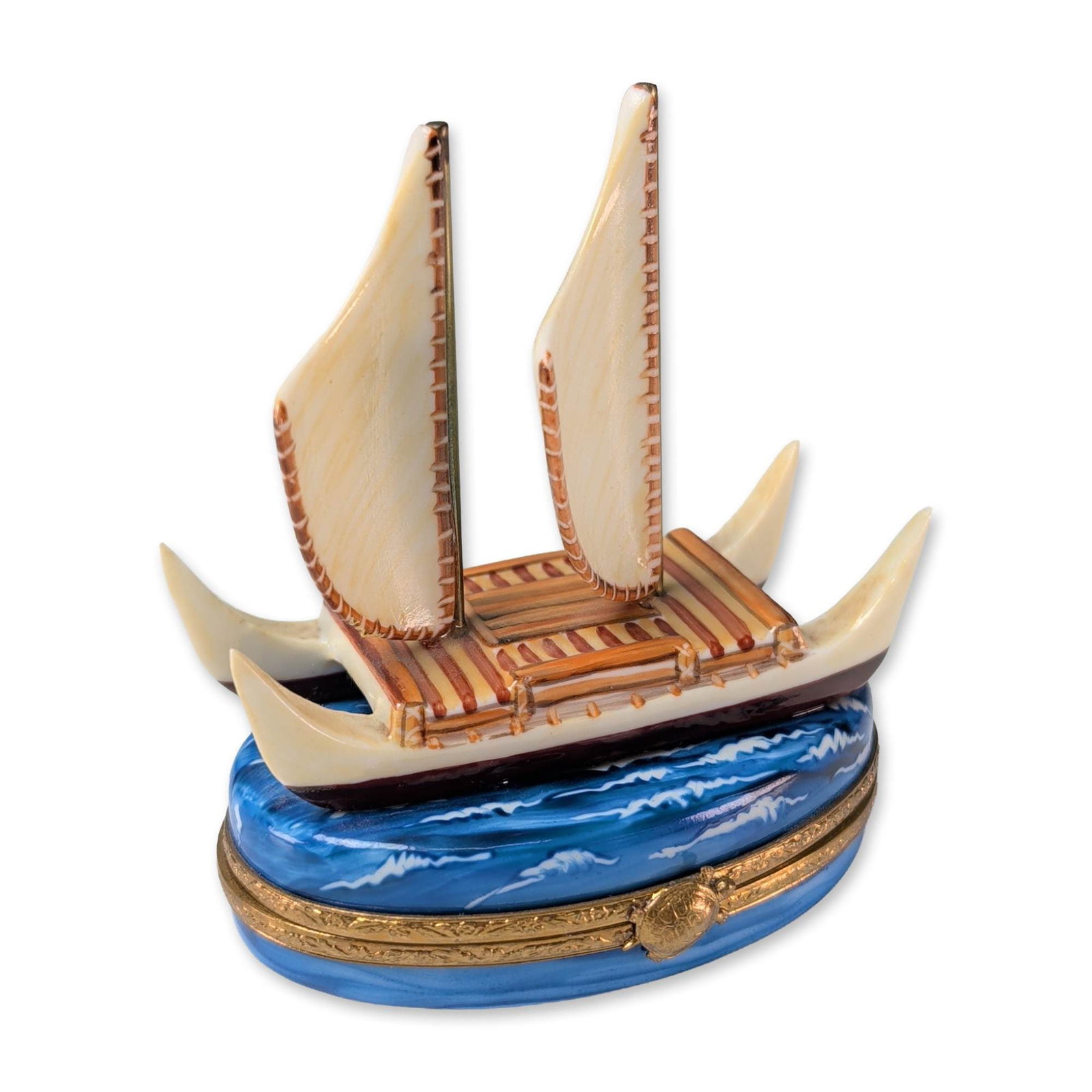 Limoges Peint Main Porcelain Outrigger Ship Trinket Box: Limoges, France, hand-painted porcelain trinket box modeled as a stylized outrigger sailing vessel atop a wave-form base. The lid features dual cream sails and a striped deck, while the oval base disp