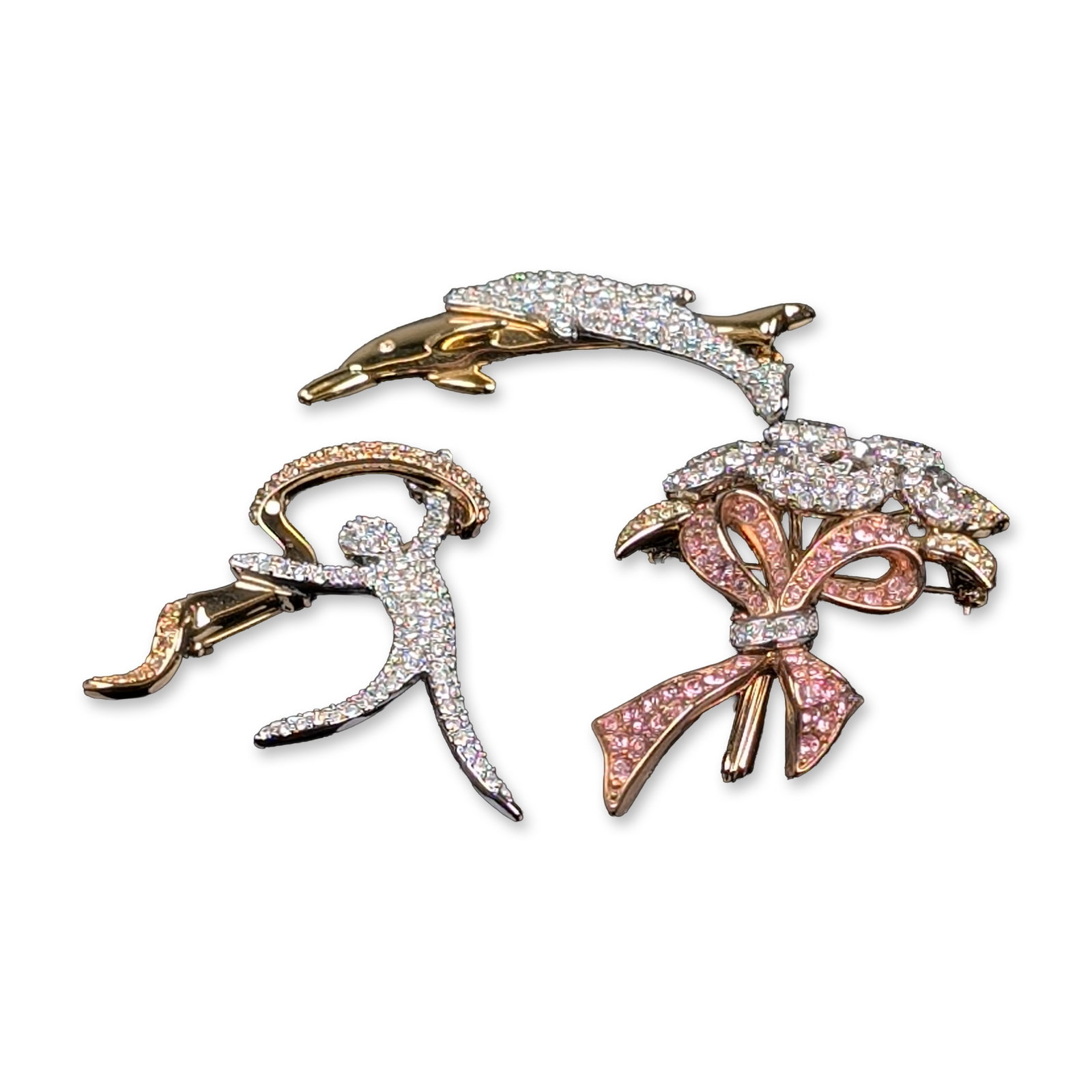 3pc Swarovski Gold-Toned Crystal Brooches: Swarovski. Trio of brooches in white, rose and yellow gold-toned plated metal featuring pave-set-colored crystals. The collection includes a floral bouquet tied with a ribbon bow, a leaping dolphin, a