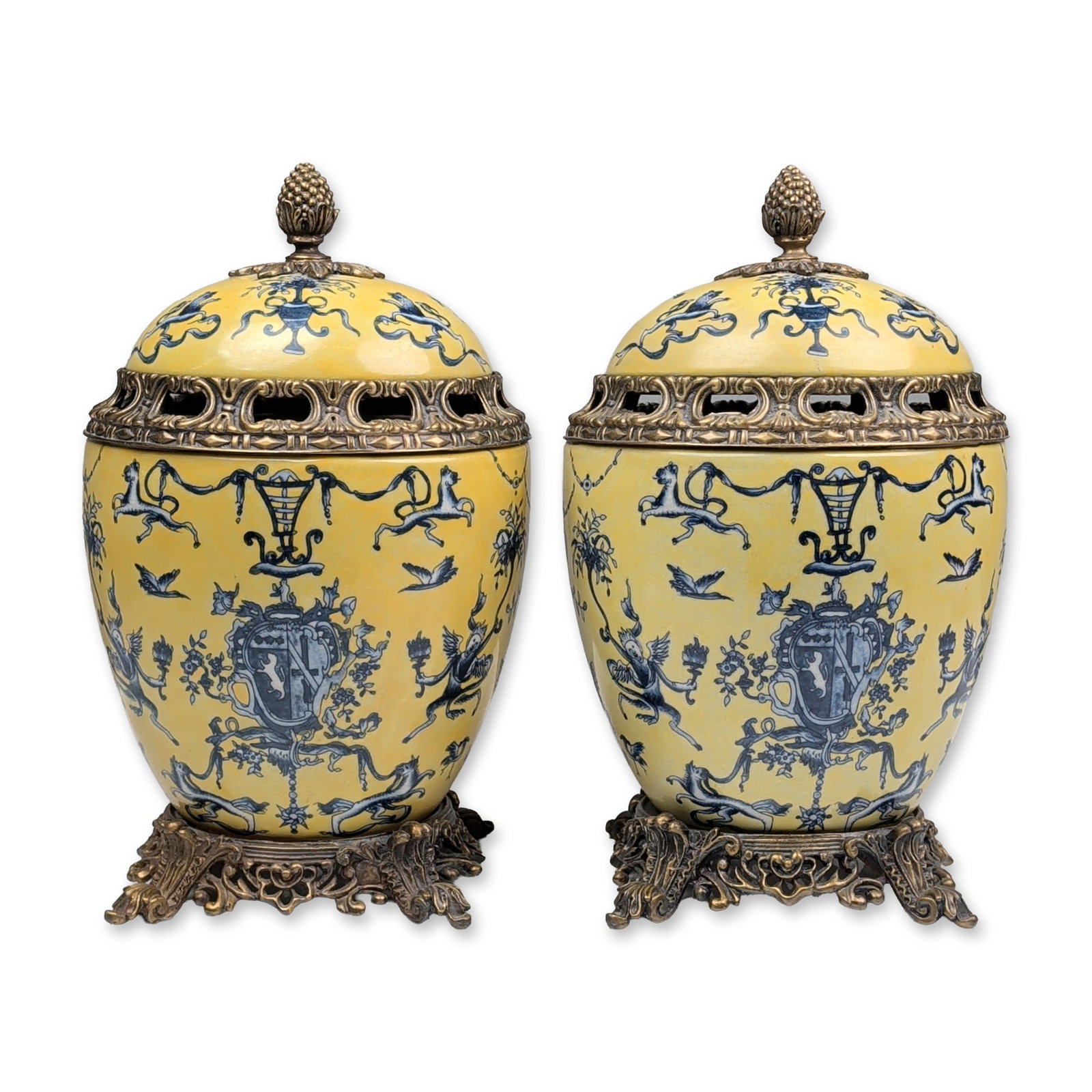 Pair of Vintage Empire Style Yellow & Blue Porcelain Lidded Potiche Urns with Pierced Bronze Mounts: Pair of decorative lidded jars in glazed earthenware with ornate gilt-metal mounts, featuring a yellow ground with hand-painted cobalt blue decoration. The style motifs include winged putti, heraldic 