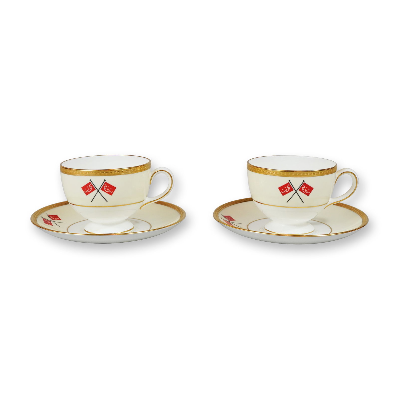 4pc Wedgwood Bone China Teacups and Saucers, Historical Kuwaiti Flags Pattern: This pair of teacups and saucers is produced in fine bone china by Wedgwood, England. The set features a cream-toned ground decorated with a motif of crossed red flags, which served as the historical 