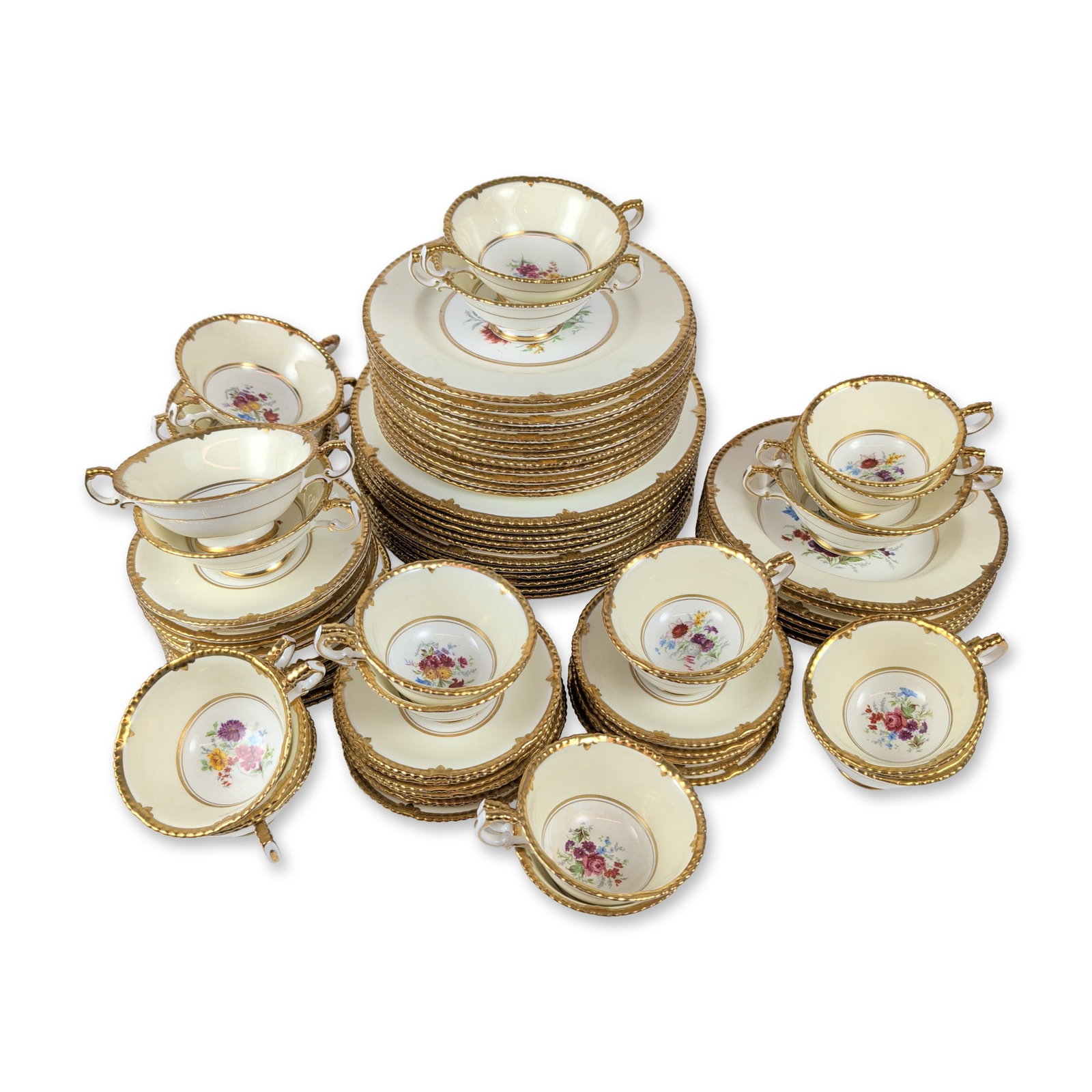 83 pc Paragon England Gilt Bone China Dinnerware: Paragon (English, mid-20th century). Table service in fine bone china, featuring an ivory ground with hand-painted central floral sprays and a heavy "beaded" or "jeweled" scalloped gilt border. The de