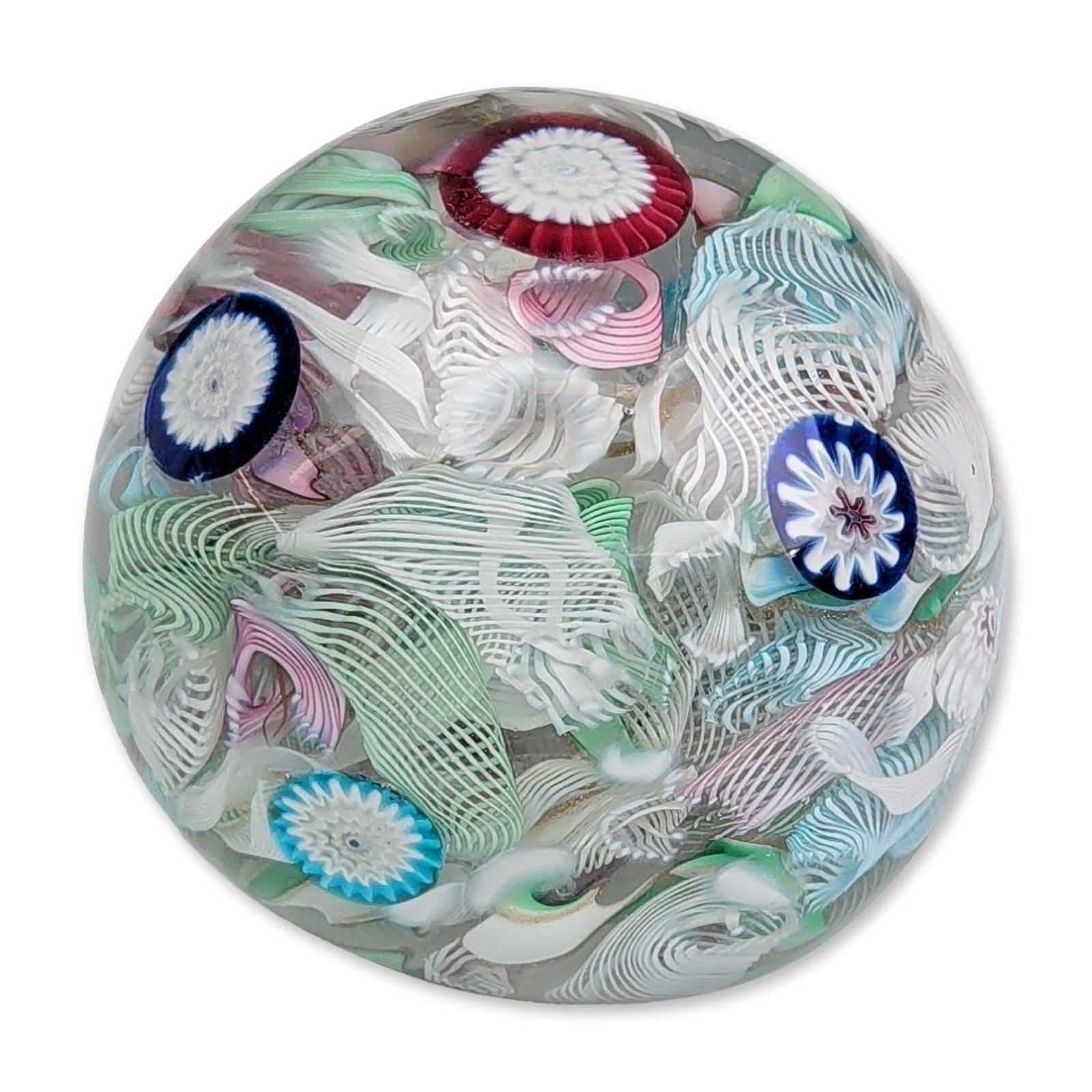 John Schneider 1981 Art Glass Scramble Paperweight: John Schneider (American, 20th century). Studio art glass paperweight in clear glass, featuring a dense scrambled interior composition of polychrome millefiori canes and twisted latticino ribbons in s