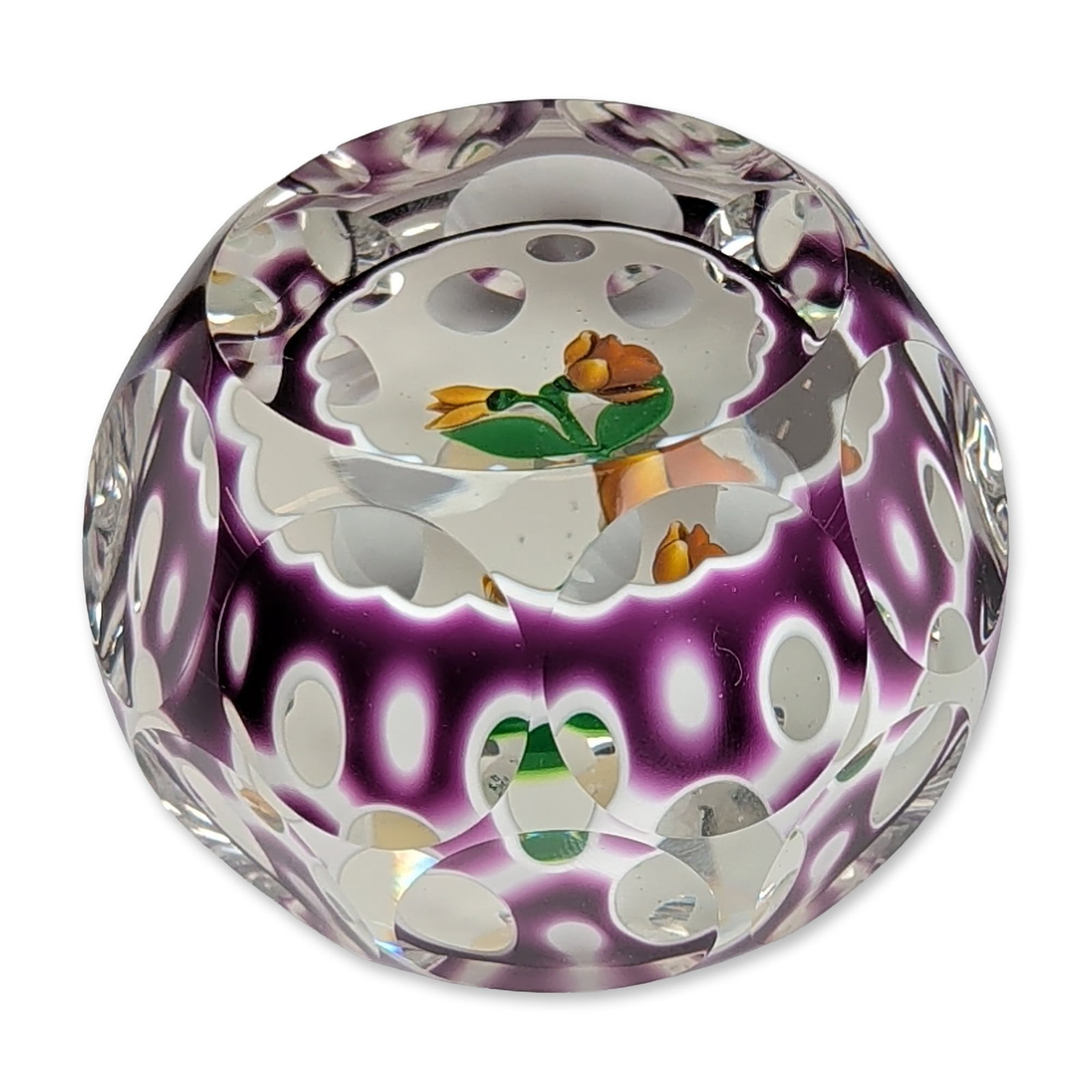 Perthshire Glass 1982 Purple Overlay Faceted Glass Paperweight: Perthshire Paperweights (Crieff, Scotland, 1982). Faceted three dimensional art glass paperweight featuring a central lampwork sulphur yellow flower and bud with green foliage. The clear glass interio