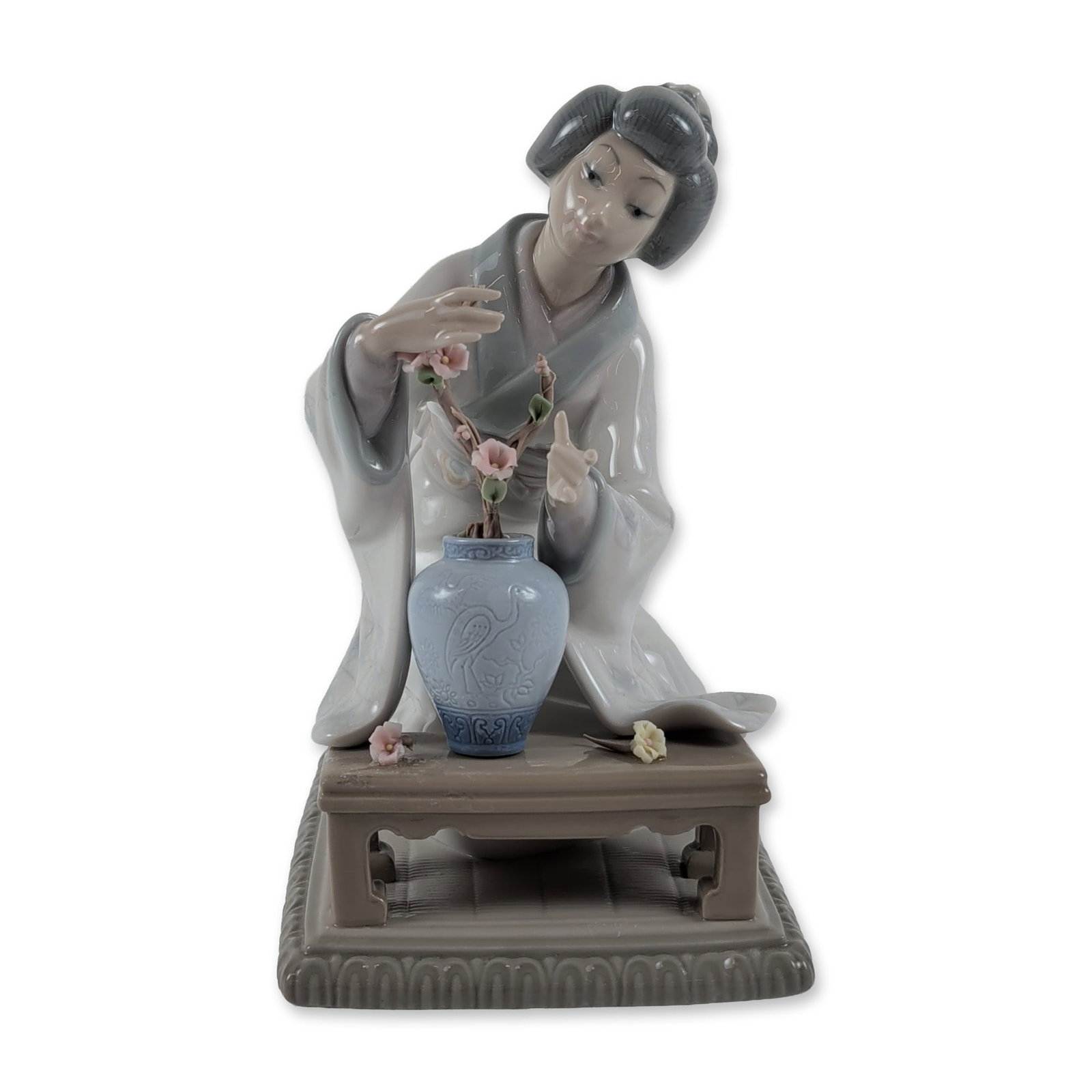 Lladro Porcelain Figurine Oriental Girl: Lladro, Spain. Glazed polychrome porcelain figurine titled Oriental Girl, model number 4840, designed by sculptor Vincente Martinez. The work depicts a Japanese woman in a traditional gray and white p