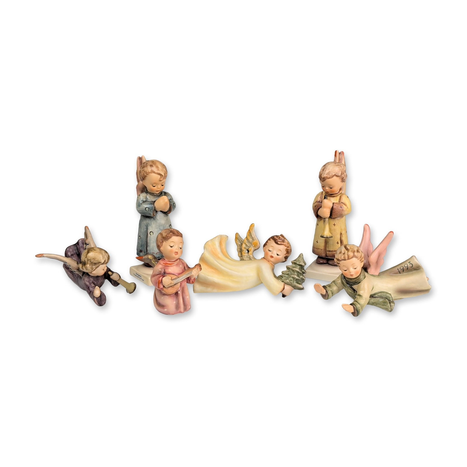Collection of Six Goebel Hummel Ceramic Angel Figurines: Goebel Hummel, West Germany. Nativity set in hand-painted ceramic with a matte finish, accompanied by a rustic wooden and straw-thatched stable. The collection includes a group of figurines: the Holy 