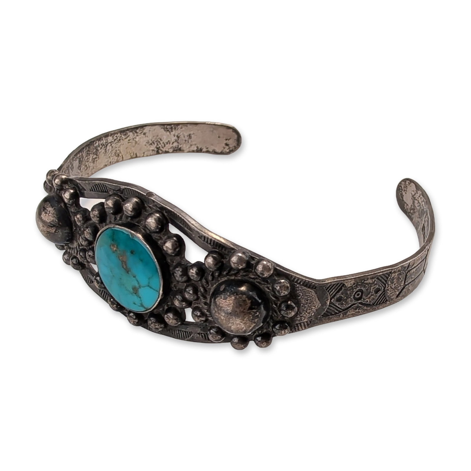 Navajo Sterling Silver Turquoise Cuff Bracelet: Southwestern cuff bracelet in sterling silver, featuring a central oval turquoise cabochon with natural brown matrix. The stone is set in a bezel and flanked by two applied hemispherical silver domes.