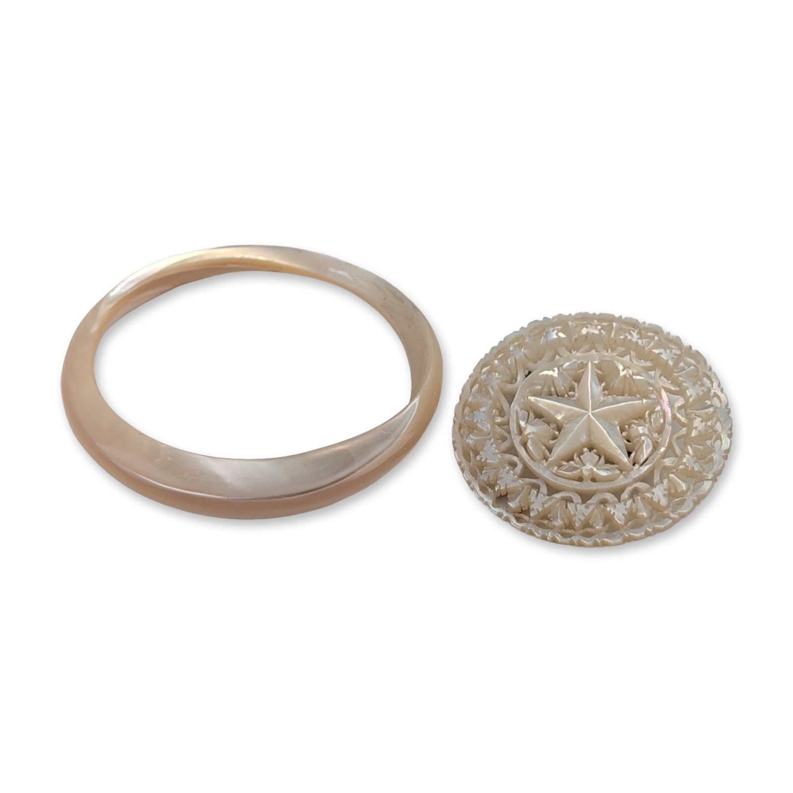 Two Carved Mother-of-Pearl Brooch Pin and Bracelet: Includes a circular brooch featuring an intricate pierced foliate scrollwork design with a central raised five-pointed star, and a single-piece bangle bracelet with a smooth, polished surface and roun