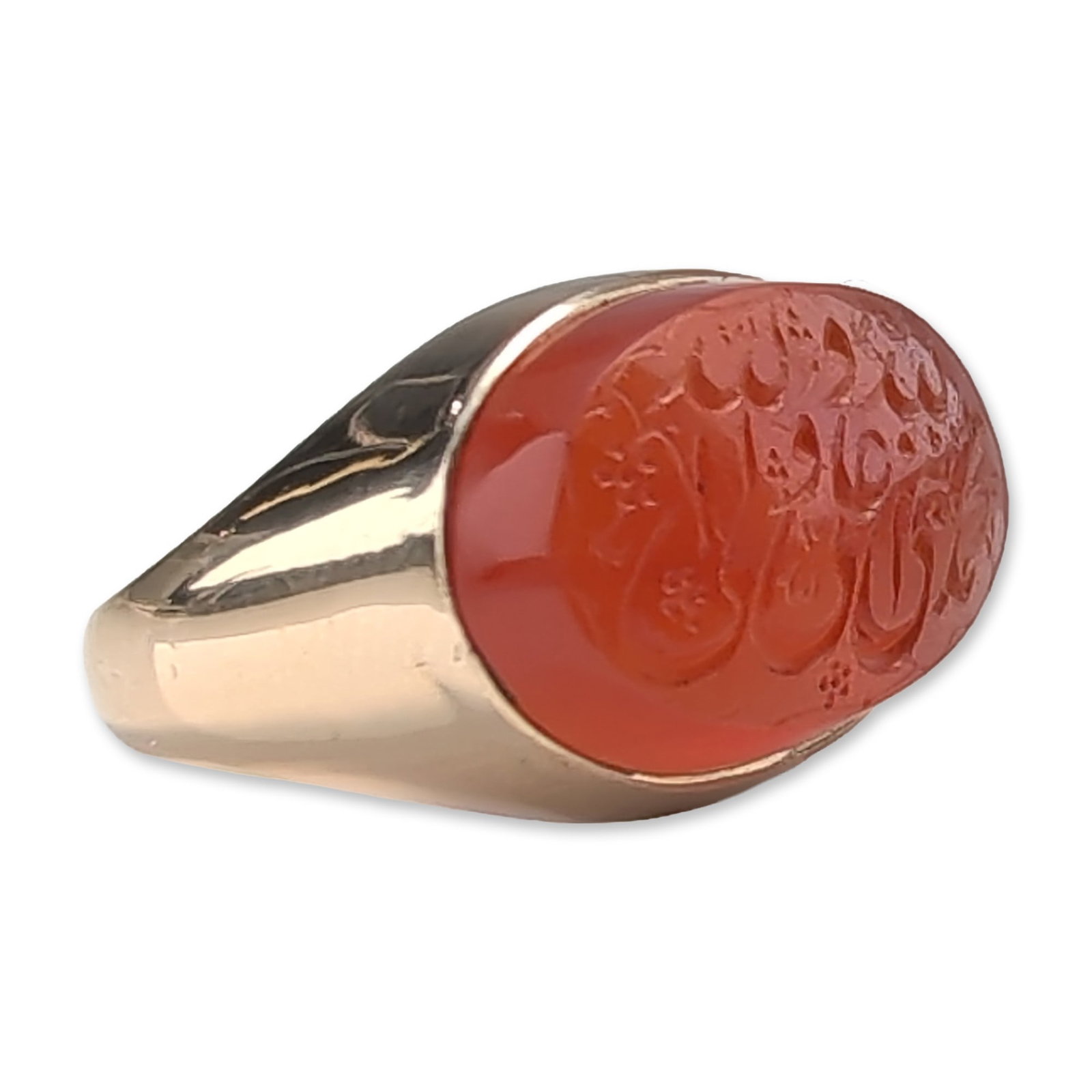 18K Gold Islamic Carnelian Signet Ring: 18K yellow gold signet ring featuring a flush-set oval carnelian intaglio. The reddish-orange stone is hand-carved with intricate Islamic calligraphy, possibly Arabic or Persian script. The mounting f