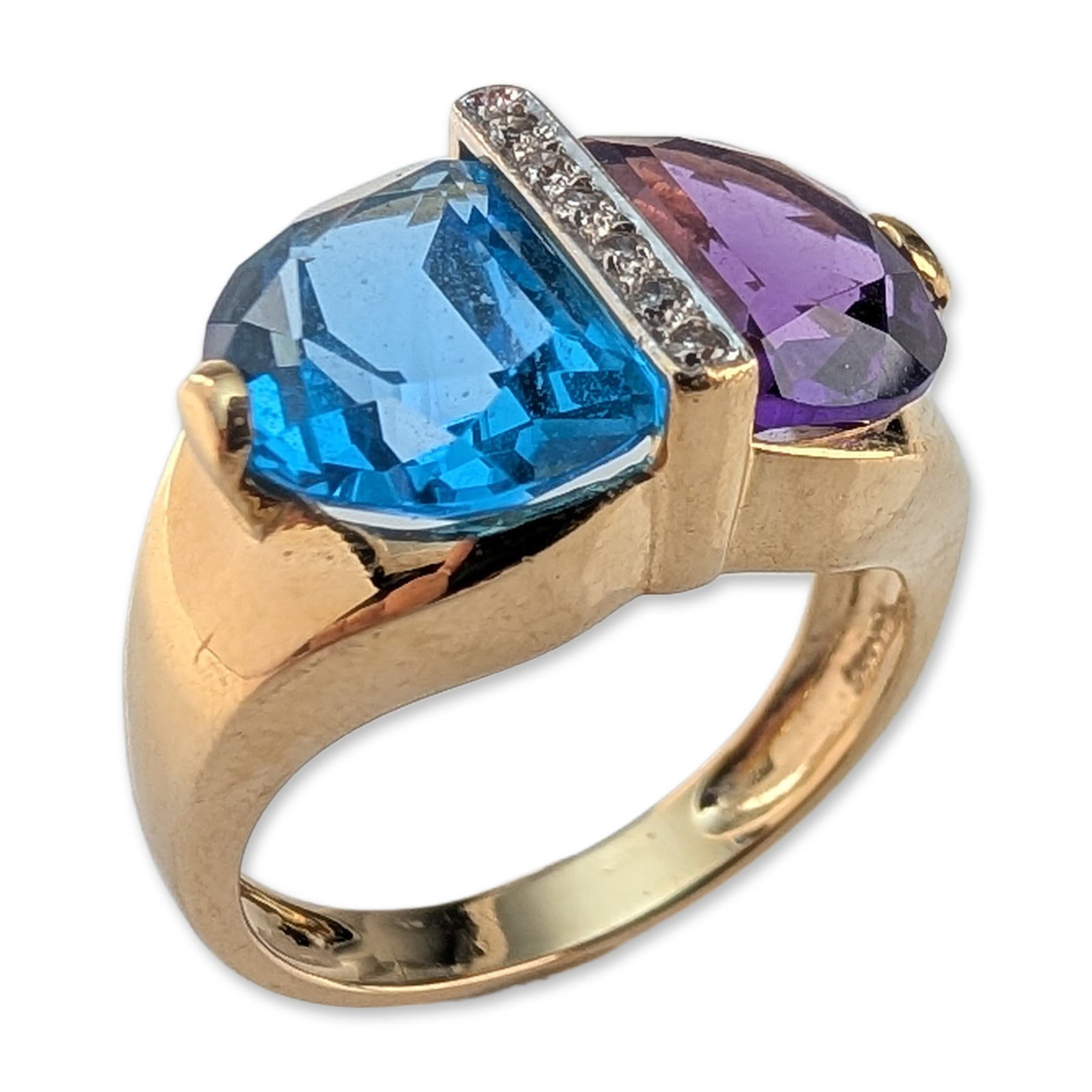 14K Yellow Gold Amethyst and Blue Topaz Diamond Ring: Modernist style cocktail ring in 14k yellow gold, featuring one modified half moon cut amethyst and one half moon cut blue topaz in a bypass setting. The gemstones are separated by a central diagonal 