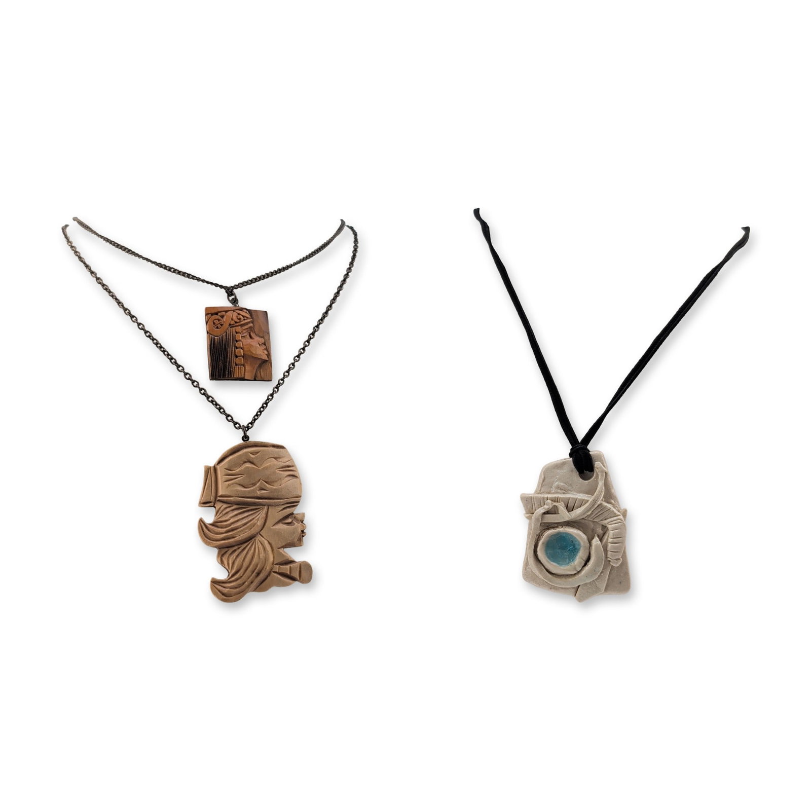 3pc Ceramic and Carved Wooden Pendant Necklaces: Group of three handcrafted necklaces featuring a variety of pendant designs and materials. Two necklaces are composed of metal link chains, each suspending a carved wooden pendant depicting a woman's 