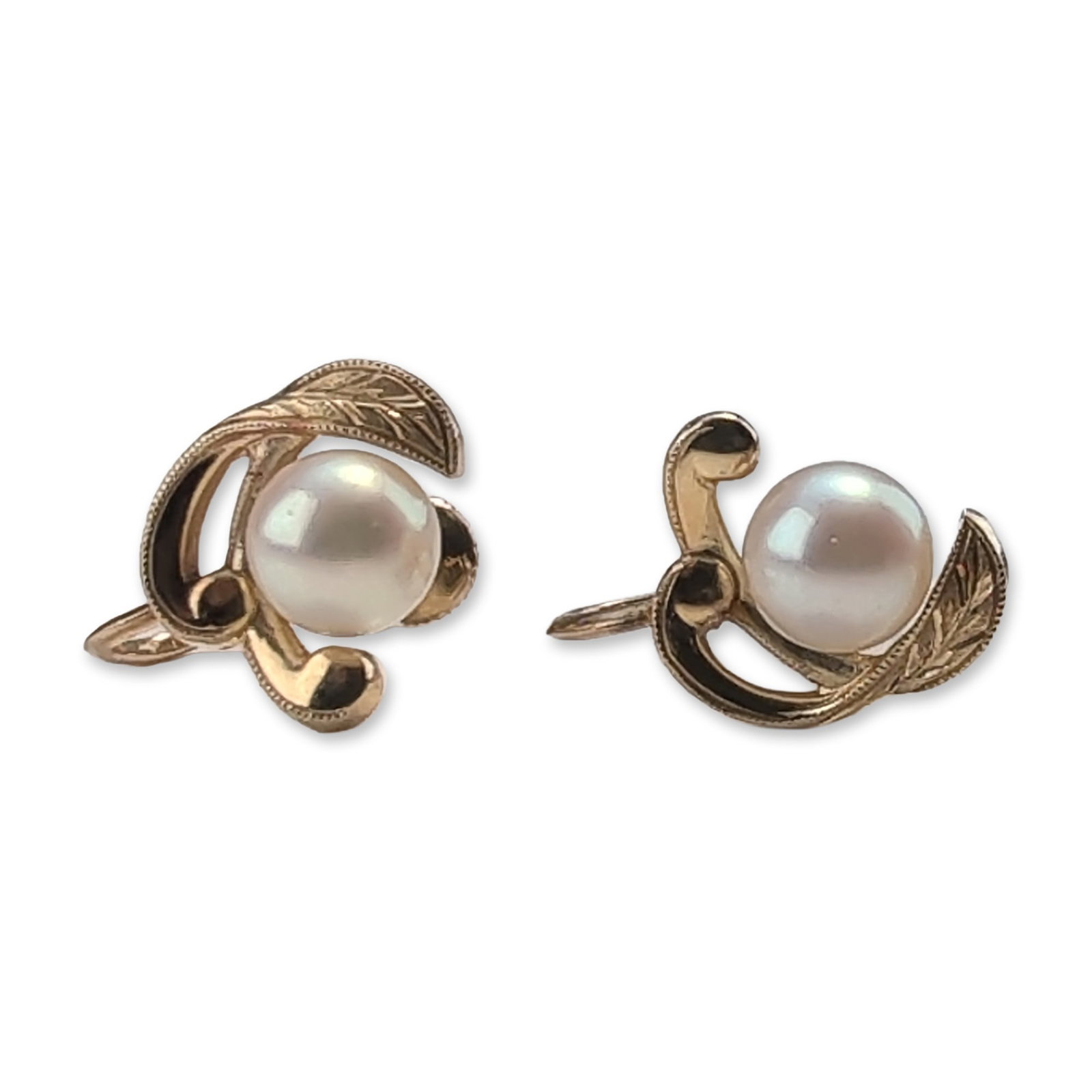 Pair of Mikimoto14K Gold Pearl Earrings: A matched pair of 14k yellow gold screw-back earrings, each featuring a central round white cultured pearl with high luster and pinkish-green orient. The pearls are cradled within a stylized organic f