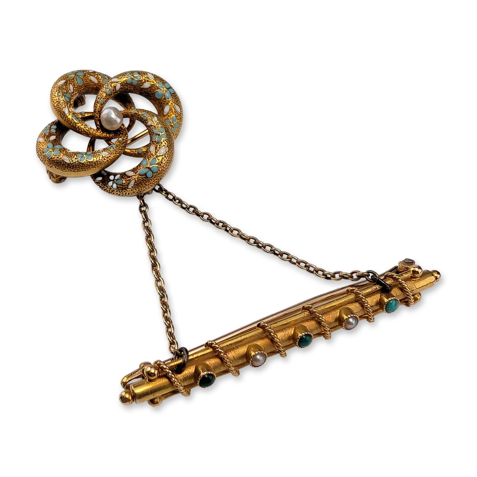 Victorian 14K Gold Enamel and Seed Pearl Brooch Set: Victorian style. Brooch set in 14K yellow gold, featuring an interlocking quatrefoil love knot design and coordinating bar pin connected by a safety chain. The main brooch is decorated with stippled s