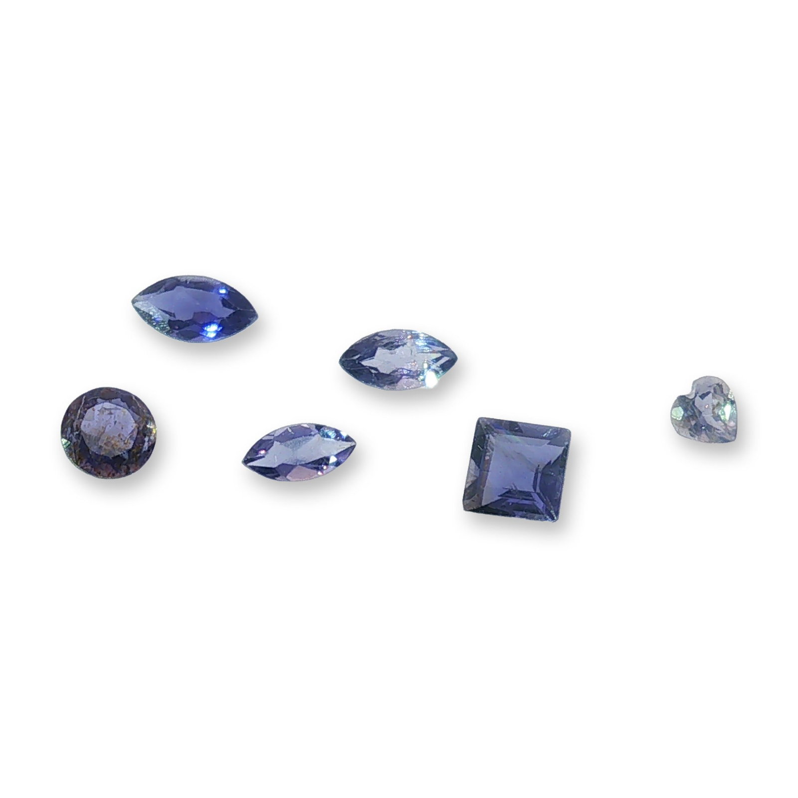 Group of Six Loose Faceted Iolites: Loose gemstone appears to be a natural peridot, featuring a classic emerald cut with step-cut facets creating a geometric pattern. The stone showcases a vibrant green hue with eye-clean clarity and sh
