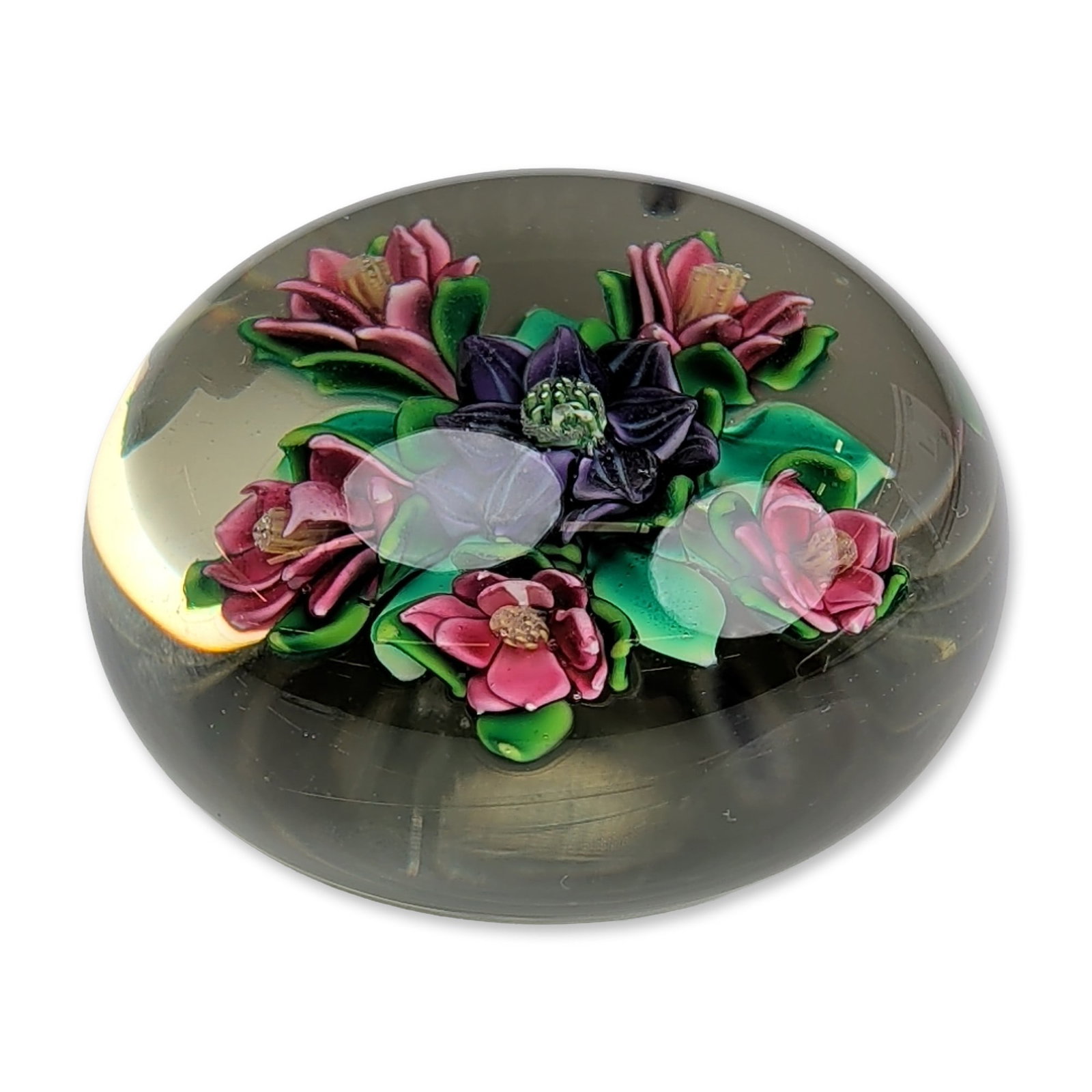 Ken Rosenfeld 1983 Floral Art Glass Paperweight: Lampwork glass paperweight featuring a central purple and black pansy with a green and white center, encircled by five pink multi-petaled blossoms with yellow and orange centers. The floral arrangemen
