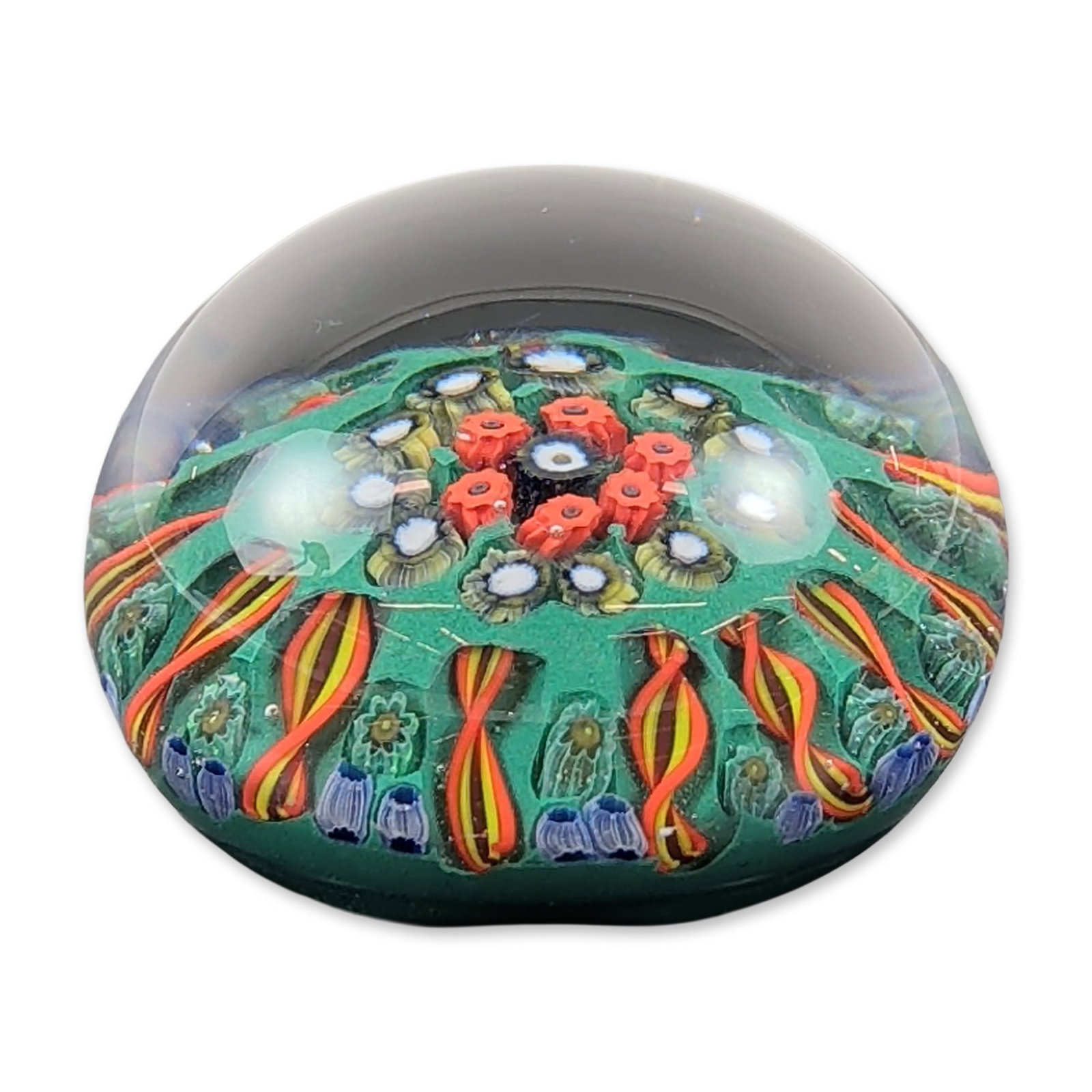 Strathearn Scotland Millefiori Glass Paperweight: Strathearn Glass paperweight from Scotland, featuring a clear glass dome over a vibrant green ground. The internal decoration consists of a concentric millefiori pattern with a central cluster of red 