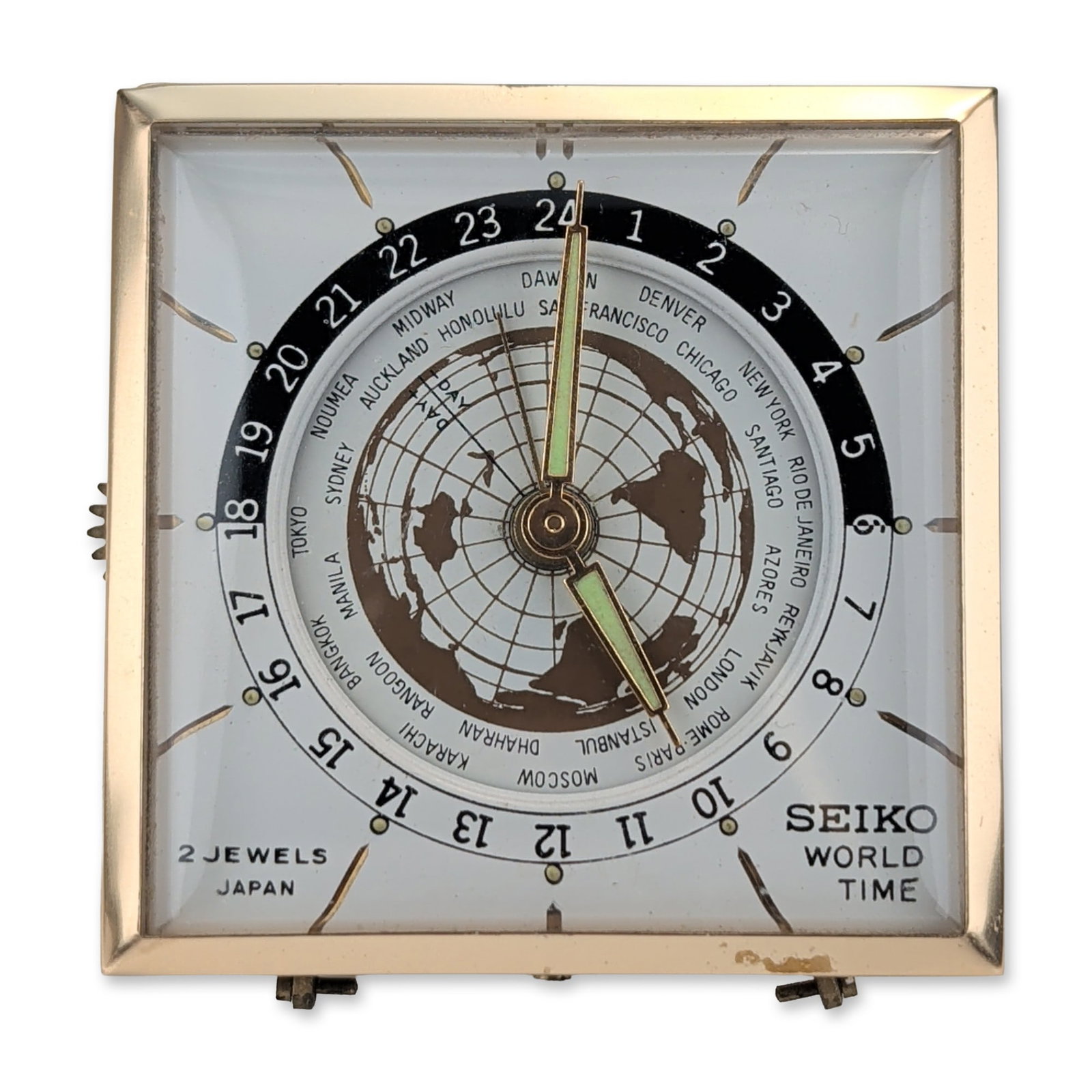Seiko World Time 2 Jewels Travel Alarm Clock: Seiko World Time travel alarm clock, mid-20th century, featuring a square gold-toned metal case. The white dial displays a central world map motif with coordinate grid, a rotating city ring, and a fix