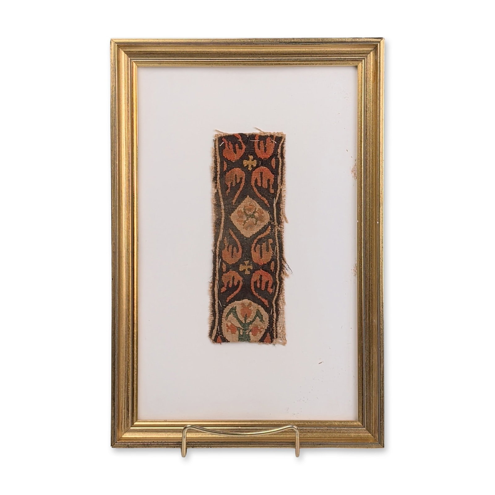 Coptic Egyptian Tapestry Textile Fragment: Coptic Egyptian tapestry-woven textile fragment, likely from a tunic or hanging. The band features repeating motifs on a dark ground, including a central diamond-shaped lozenge with a four-petaled flo