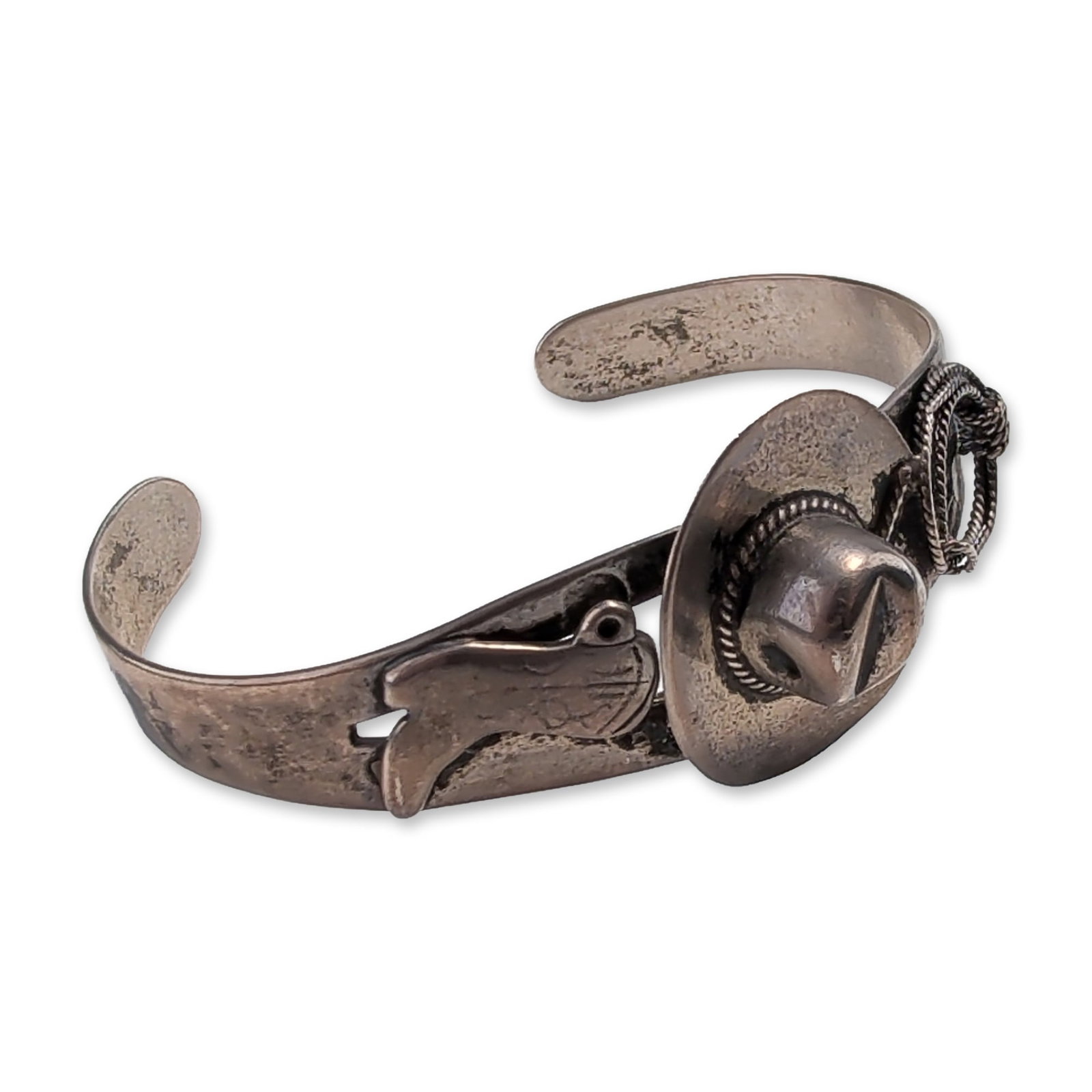 Navajo Vintage Sterling Silver Cowboy Motif Cuff: Navajo Western Americana cuff bracelet in sterling silver, featuring three-dimensional high-relief motifs including a central cowboy hat with a twisted rope hatband, a cowboy boot, and a coiled lasso.