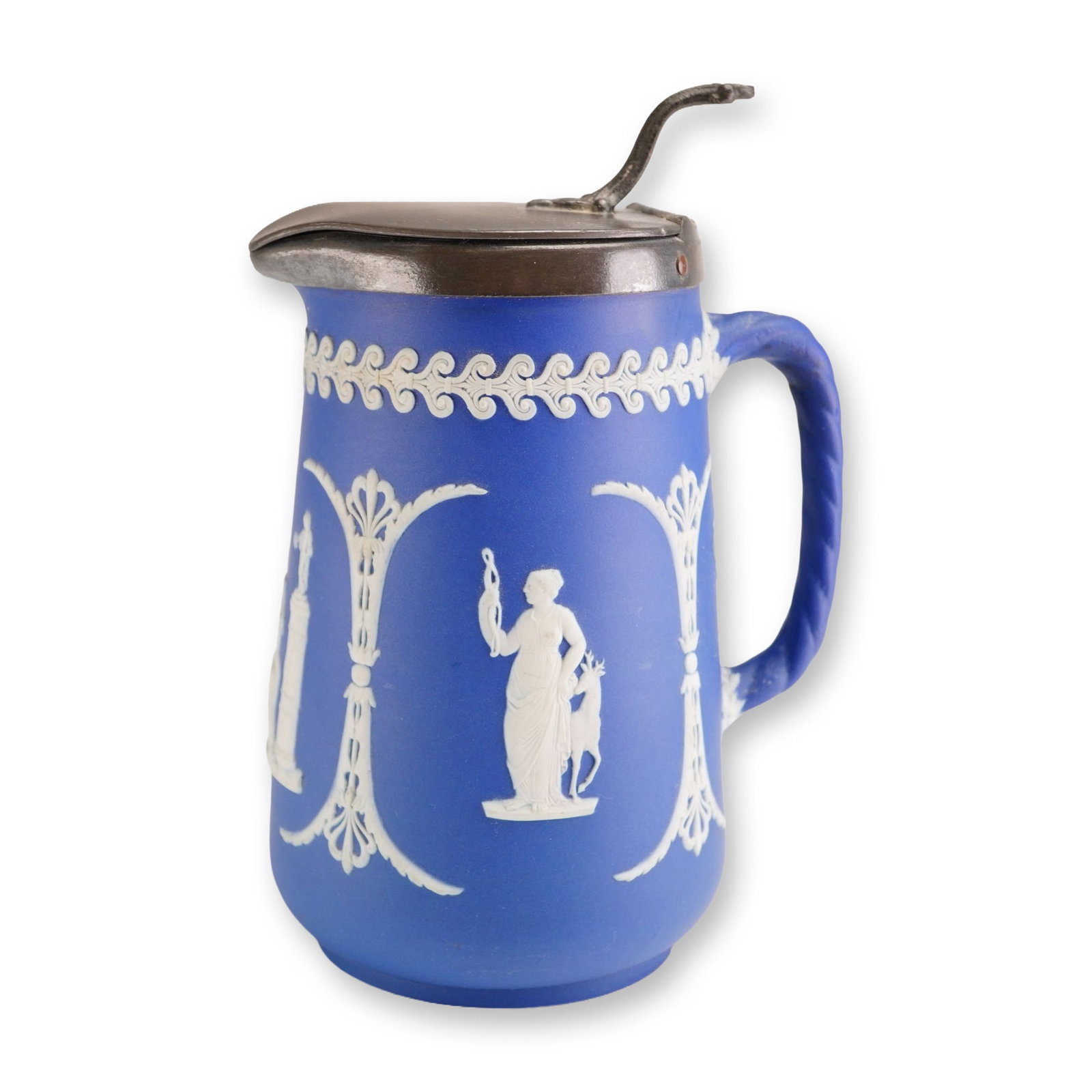 Wedgwood Jasperware Dip Portland Blue Pitcher with Metal Lid: This 19th-century English stoneware pitcher is manufactured by Wedgwood in their signature Jasperware style. The piece features a dark cobalt blue dip body with applied white bas-relief sprigged decor