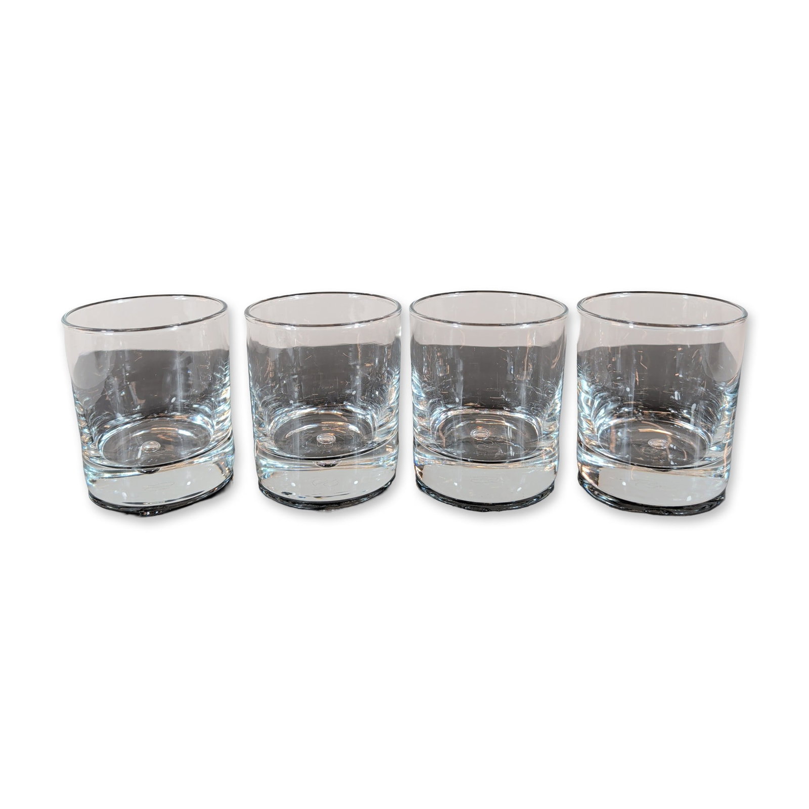 4pc Pasabahce Turkey Crystal Old Fashioned Glasses: Set of four Pasabahce drinking glasses in clear colorless crystal. Each glass features a cylindrical form with a heavy, weighted base detailed with an ergonomic curved indentation. The underside of ea