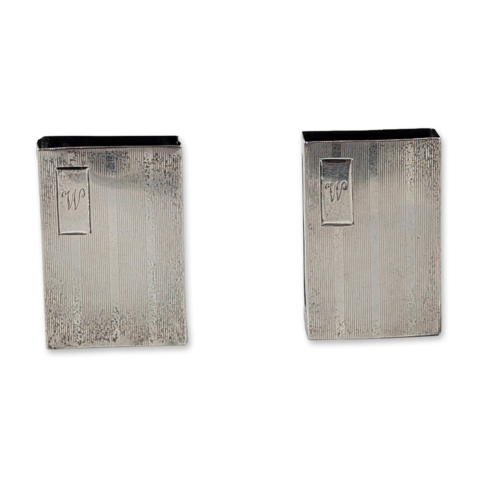 2pc Webster Sterling Silver Engine Turned Matchbox Sleeves: Sterling silver matchbox sleeves featuring a fine engine-turned linear pattern. The rectangular sleeves are designed with open ends and an elongated oval cutout on one narrow side to facilitate the