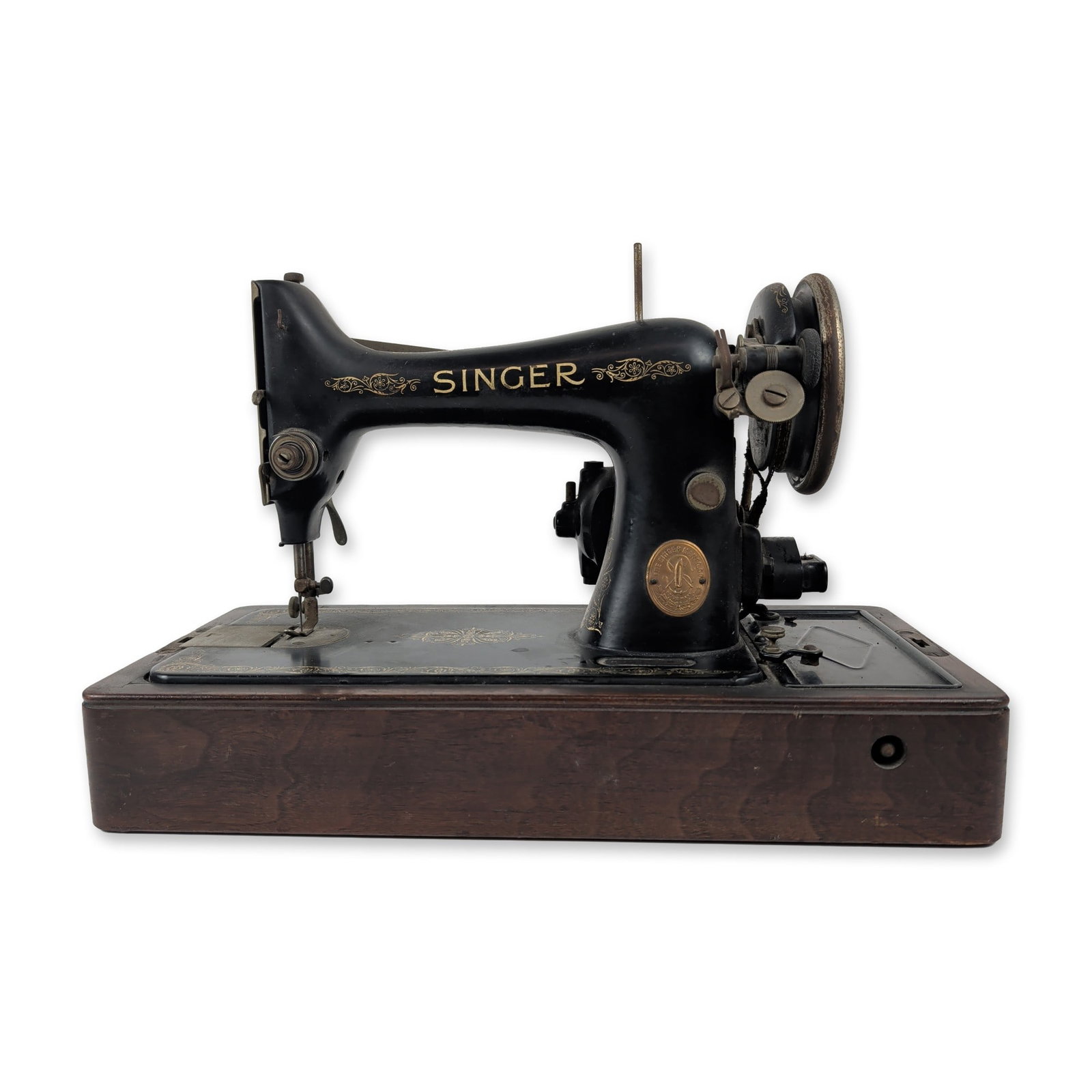Singer Model 99 Electric Sewing Machine: A black cast iron electric sewing machine by the Singer Manufacturing Company, mounted on a wooden base. The arm bears gold-toned brand lettering, while the base and pillar are adorned with delicate