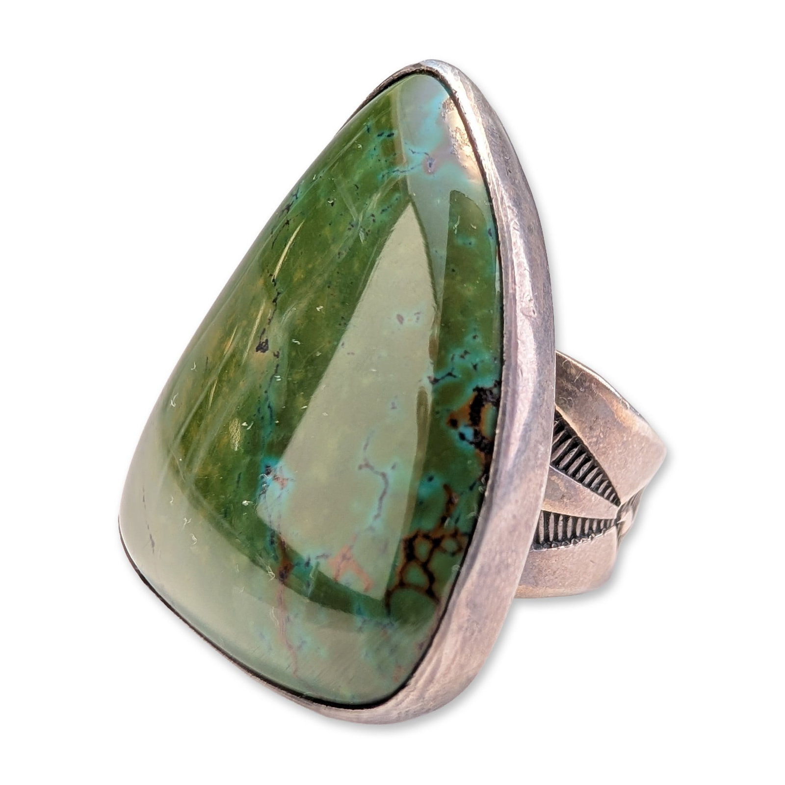 Southwestern Sterling Silver and Turquoise Statement Ring: Southwestern style statement ring in sterling silver, featuring a large bezel-set triangular cabochon of turquoise with olive green coloration, sky blue patches, and dark spiderweb matrix. The ring is